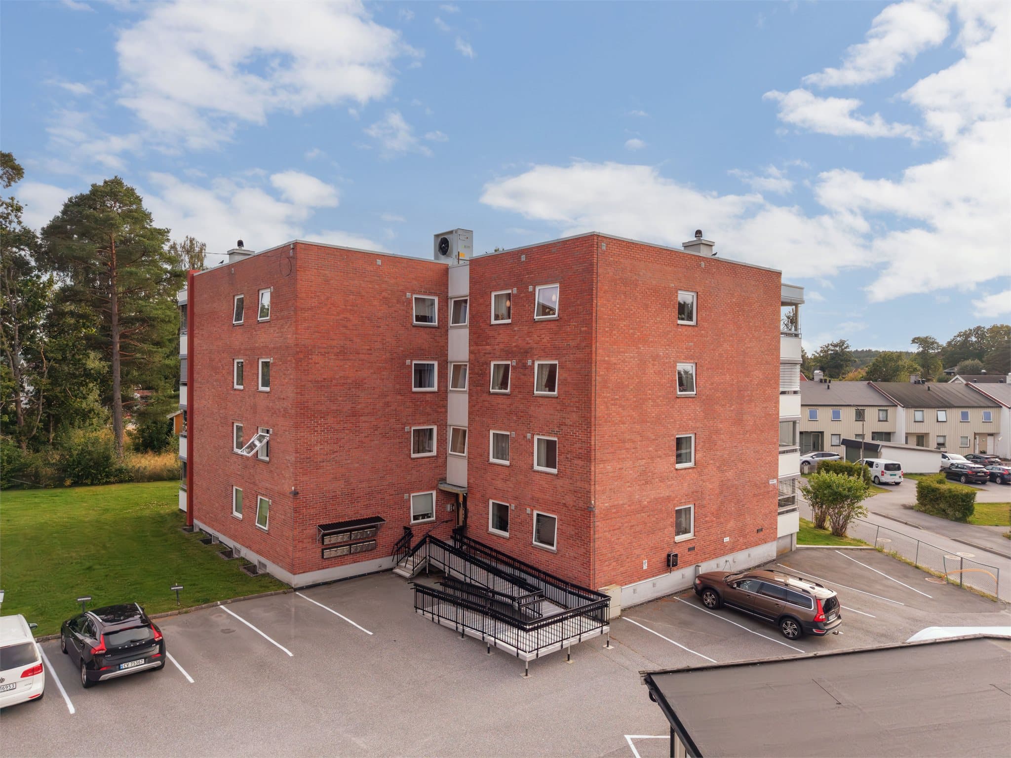 Bygningen har fasader forblendet med teglstein og adkomst via både trapp og rampe.
