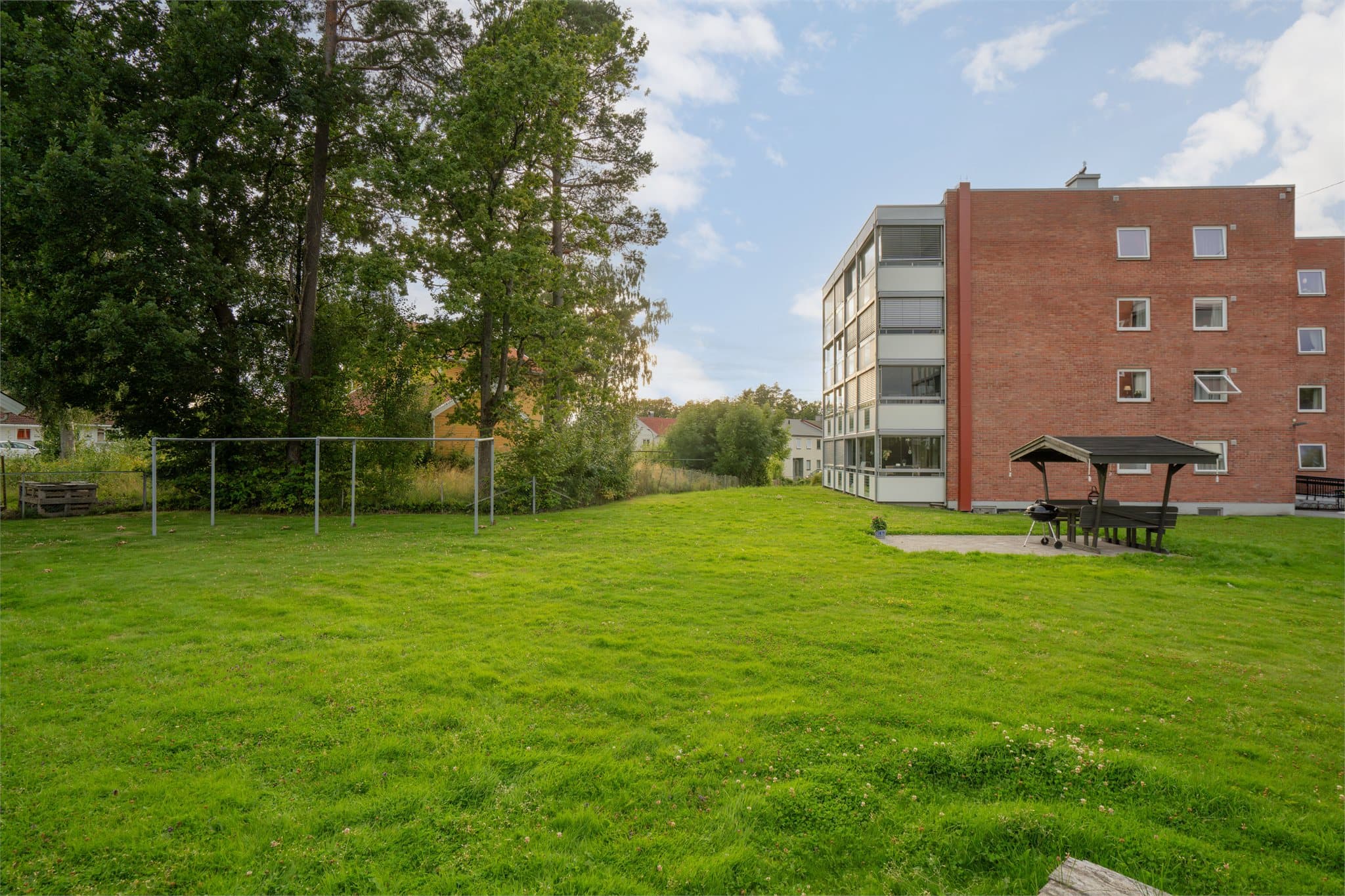 Store, felles grøntarealer med plen og sittegrupper.