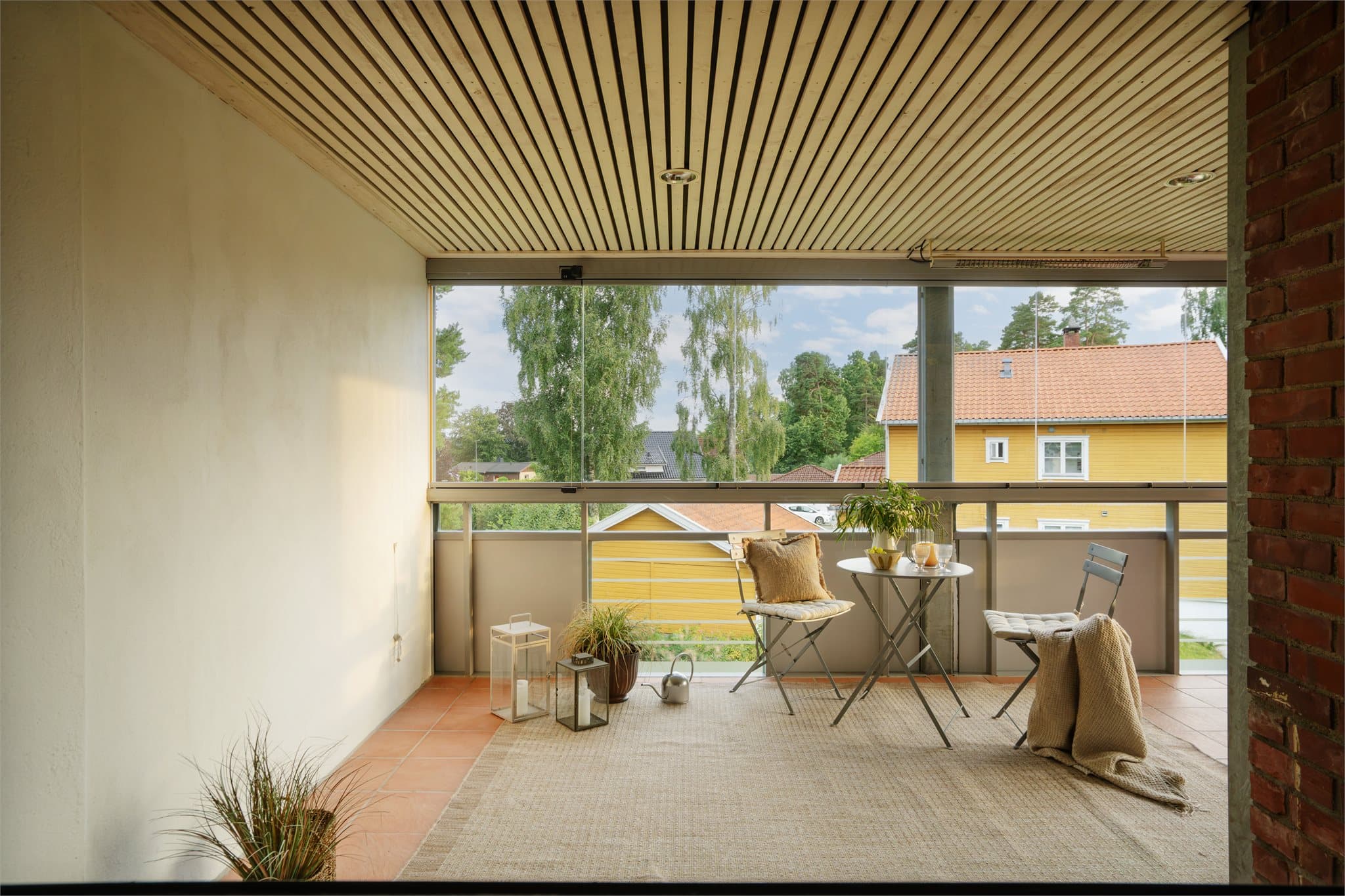 Balkongen har flislagt gulv og spilekledd himling med innfelte downlights.