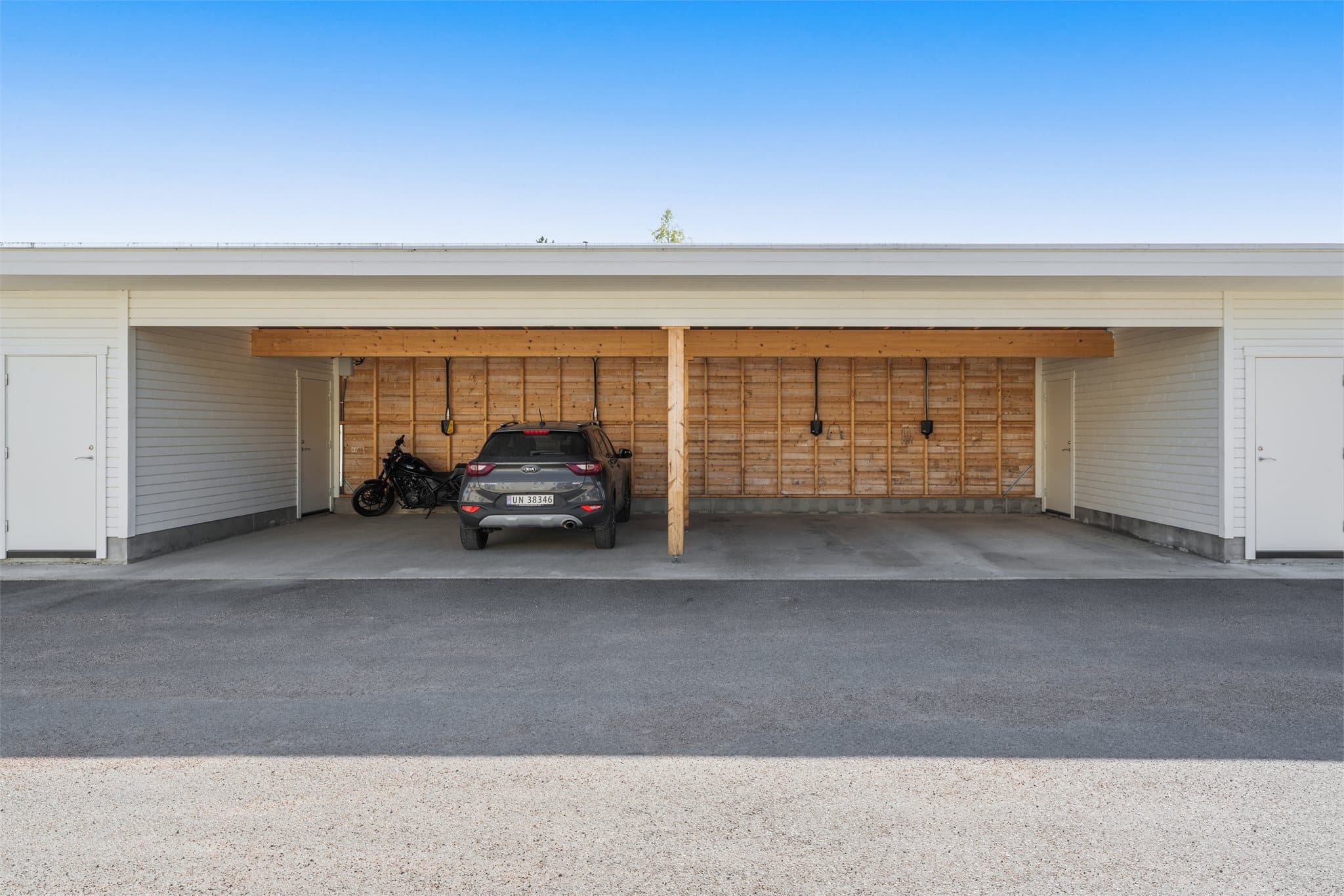 Det disponeres egen carport (helt til høyre i bildet) med ladeboks via sameiet, samt tilknyttet sportsbod.