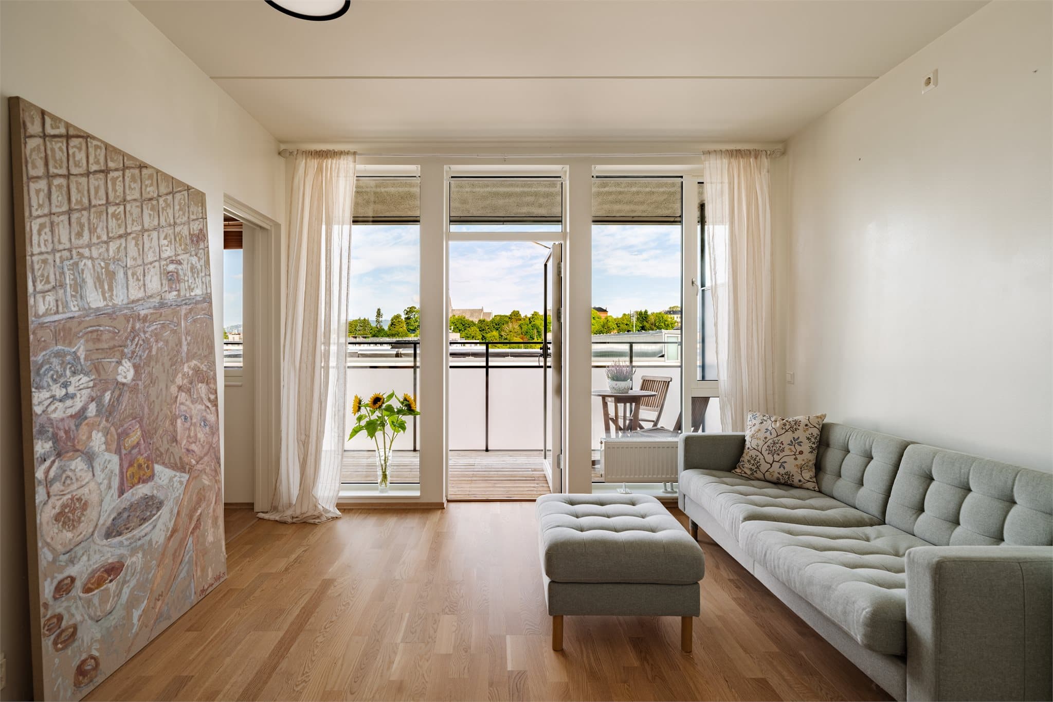 Rommet har store vinduer på endeveggen som inviterer bådet lyset og solen inn