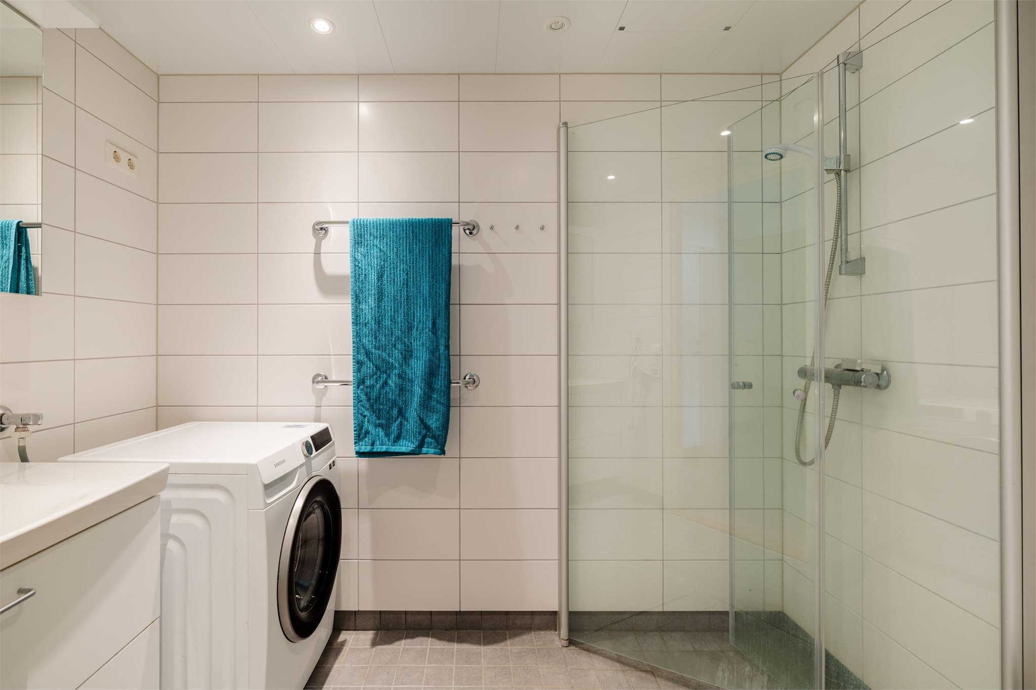 Badet har flislagte vegger, flislagt gulv med elektriske varmekabler og panelplater i tak