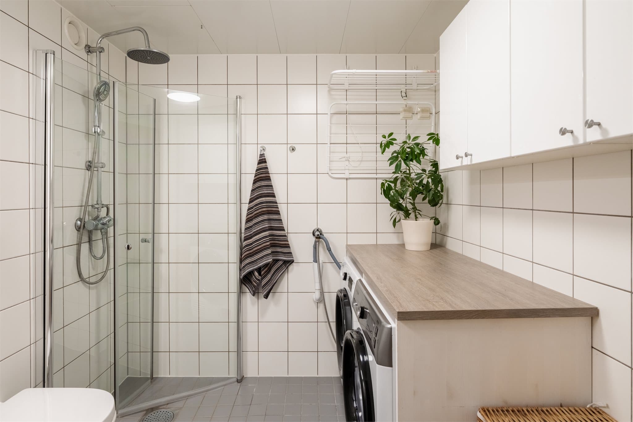 Badet har opplegg for vaskesøyle med en praktisk benkeløsning over.