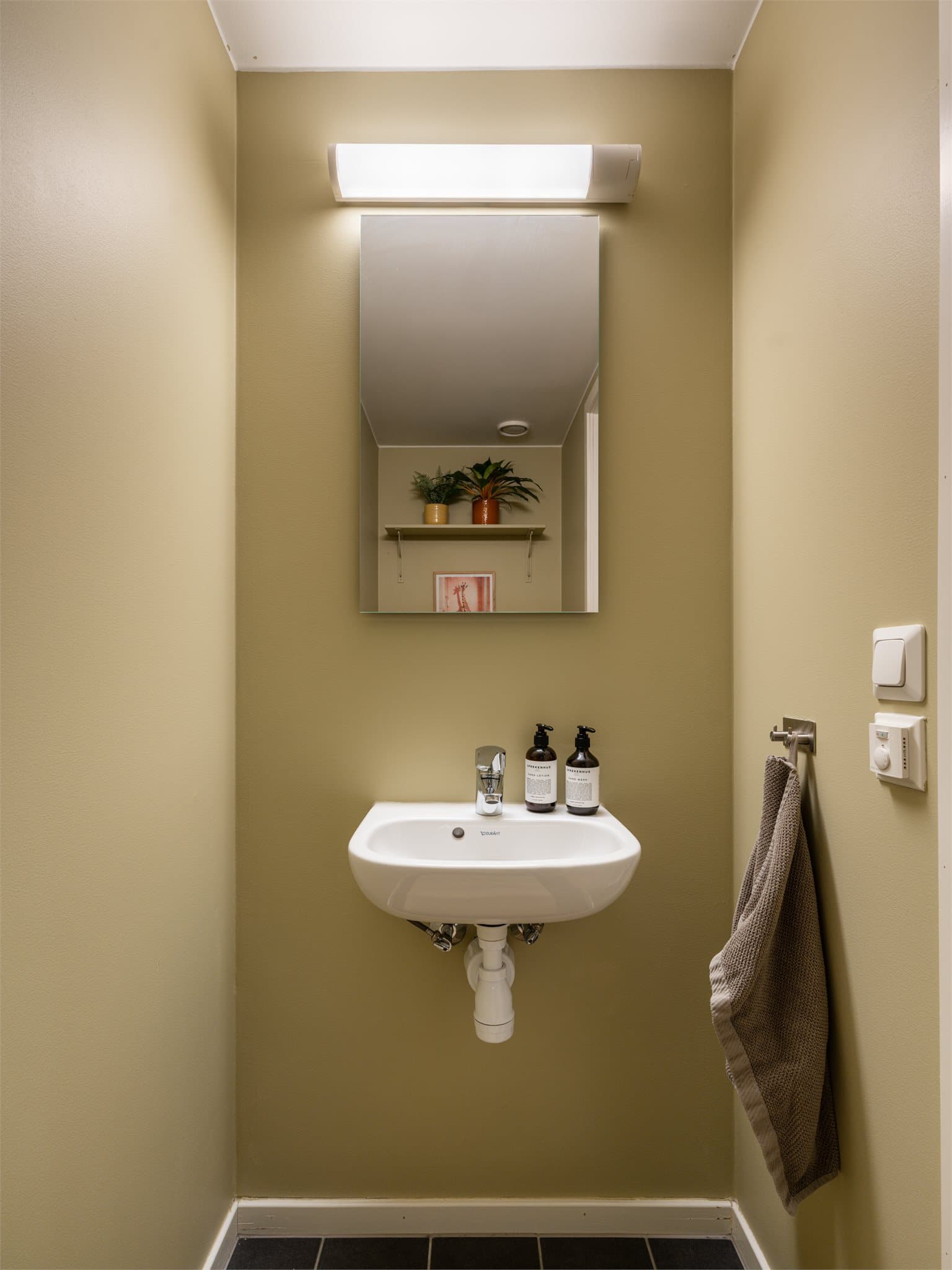 Toalettet er malt i en stilfull farge og har fliser på gulv.