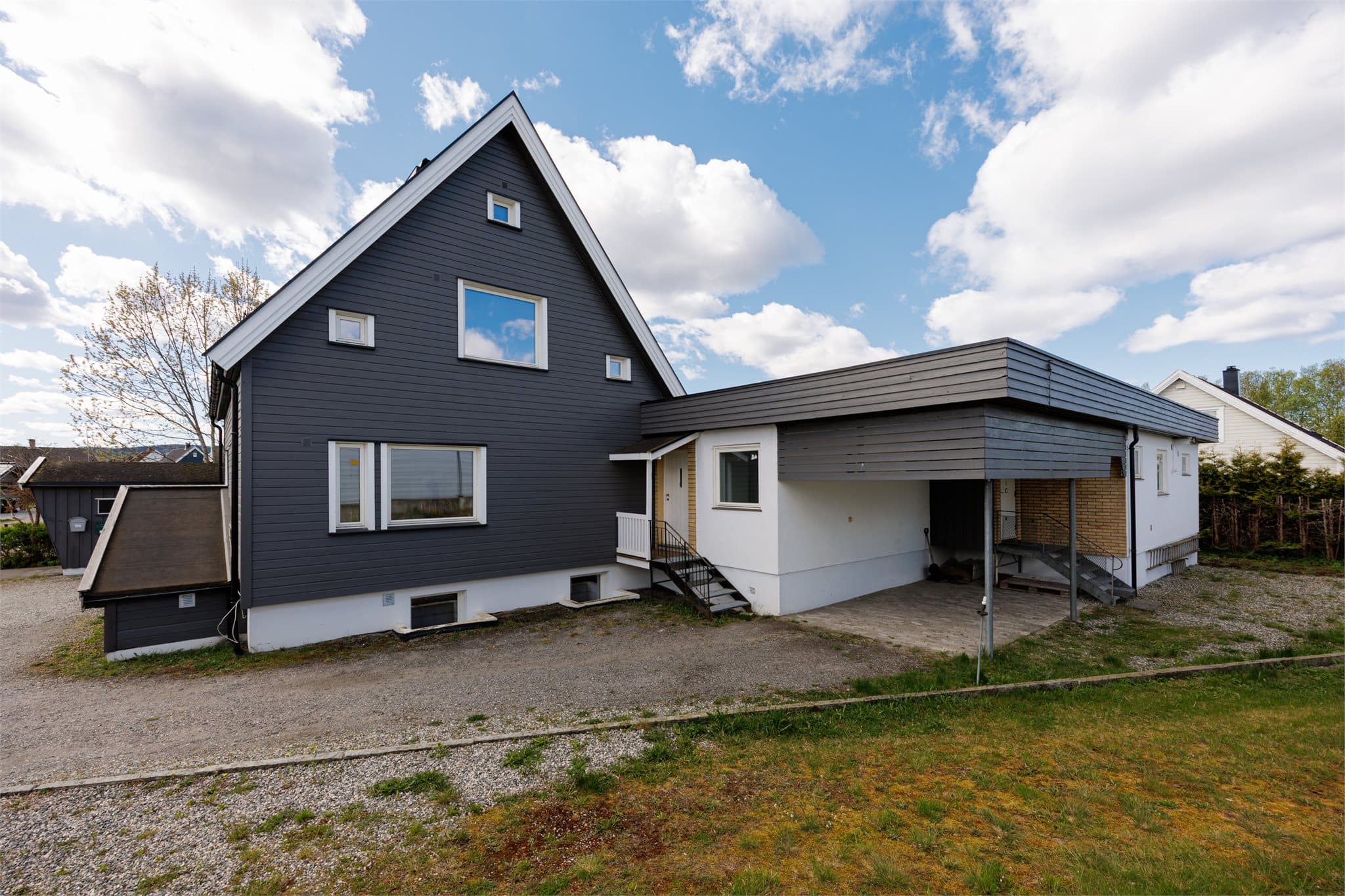 Inngangen til enhet 1A midt i bilde - Denne delen av huset fikk nytt panel, nytt tak og vinduer i 2016. Inngangen til enhet 1B til høyre.
