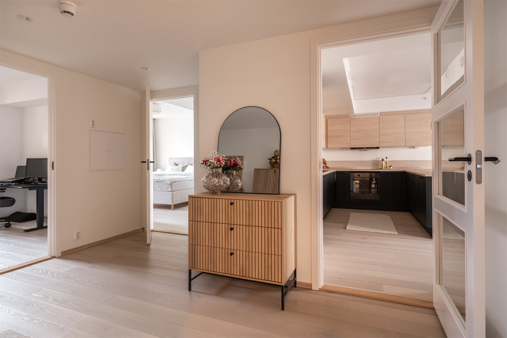 Gangen leder videre inn mot det åpne stue- og kjøkkenområdet.