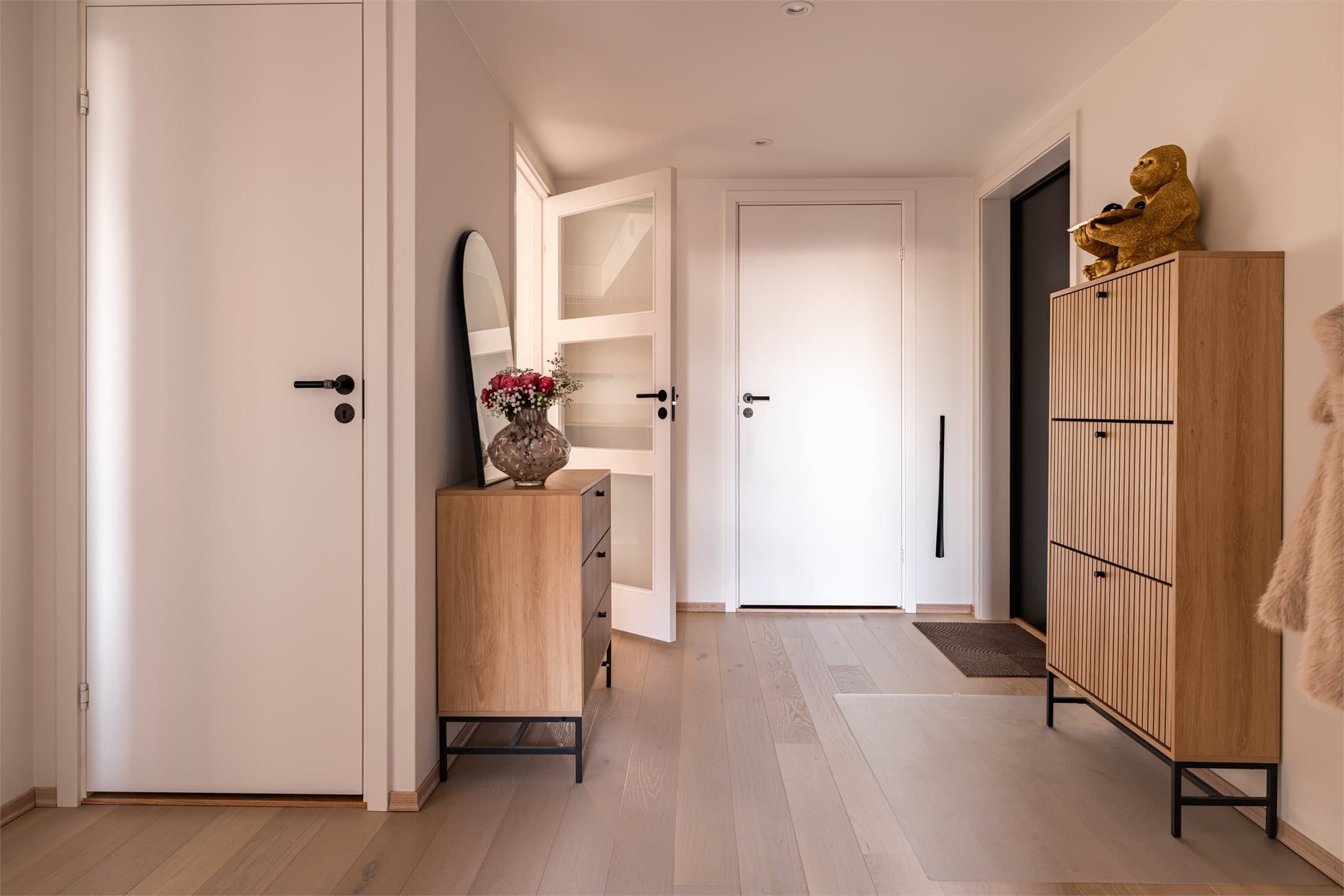 Gjennomgående eikeparkett og hvite, glatte innerdører gir et helhetlig inntrykk.