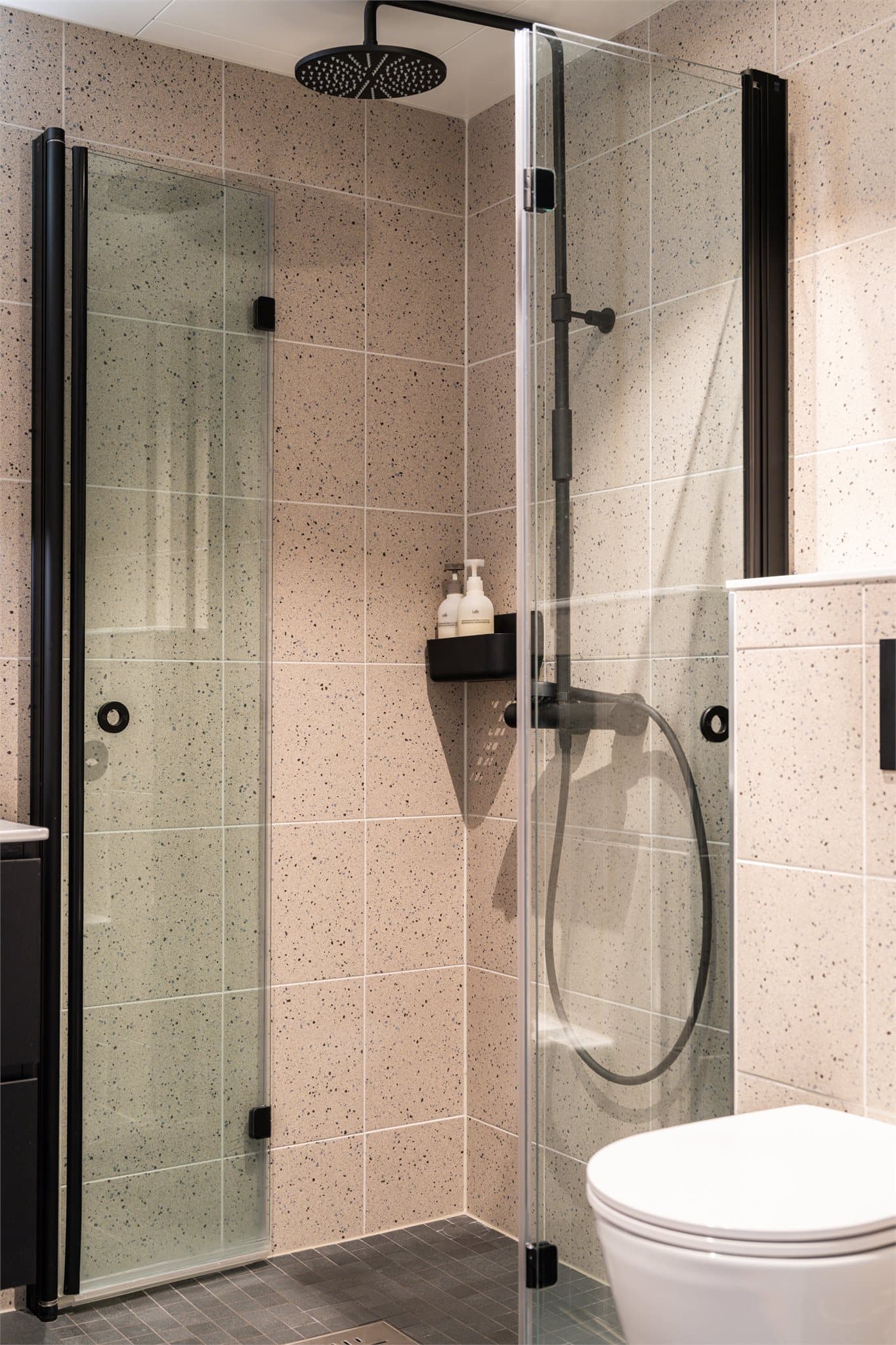 Badet er utstyrt med innfellbare dusjvegger i glass og downlights i himling.