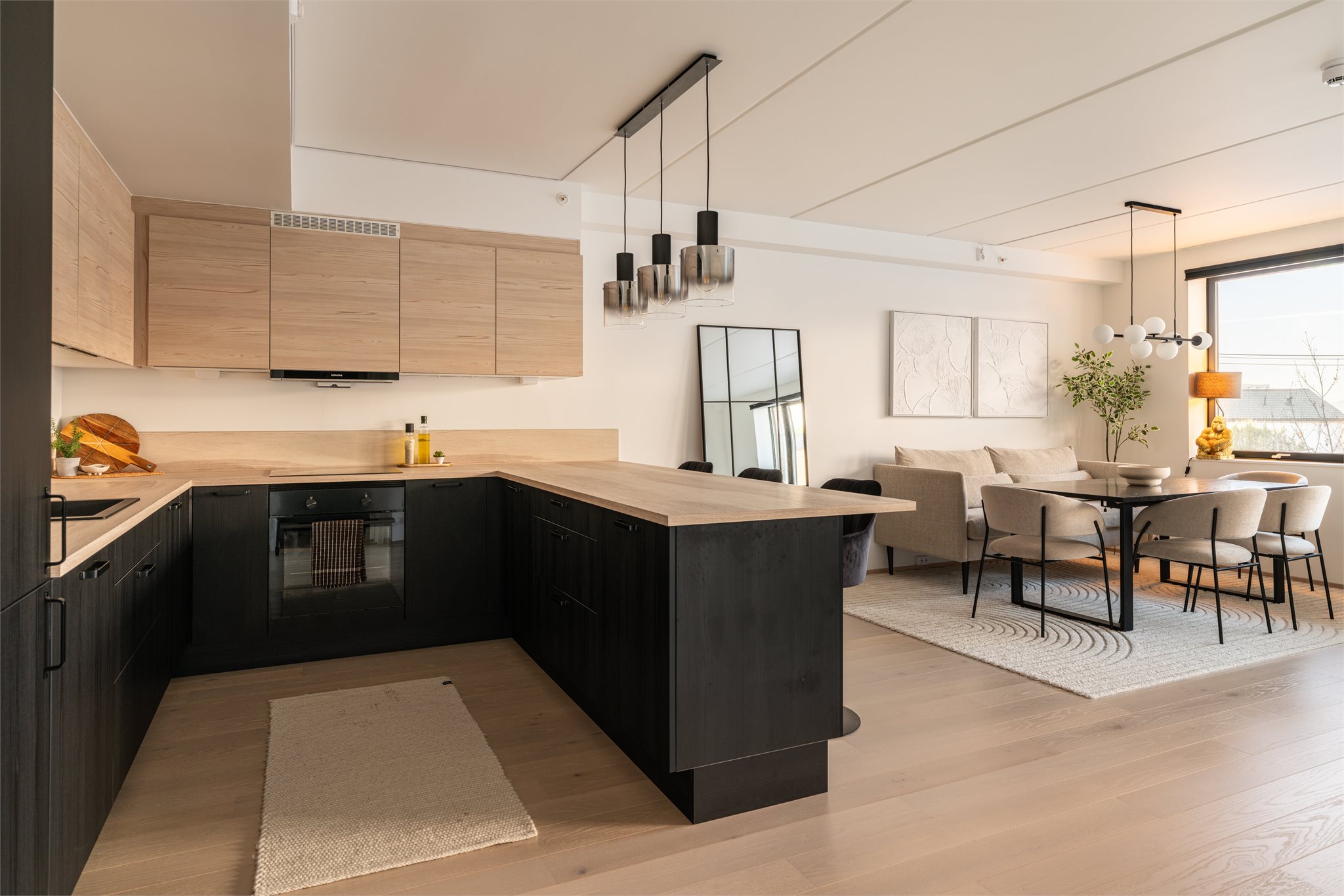 Den åpne løsningen mellom stue og kjøkken skaper en sosial og luftig sone.