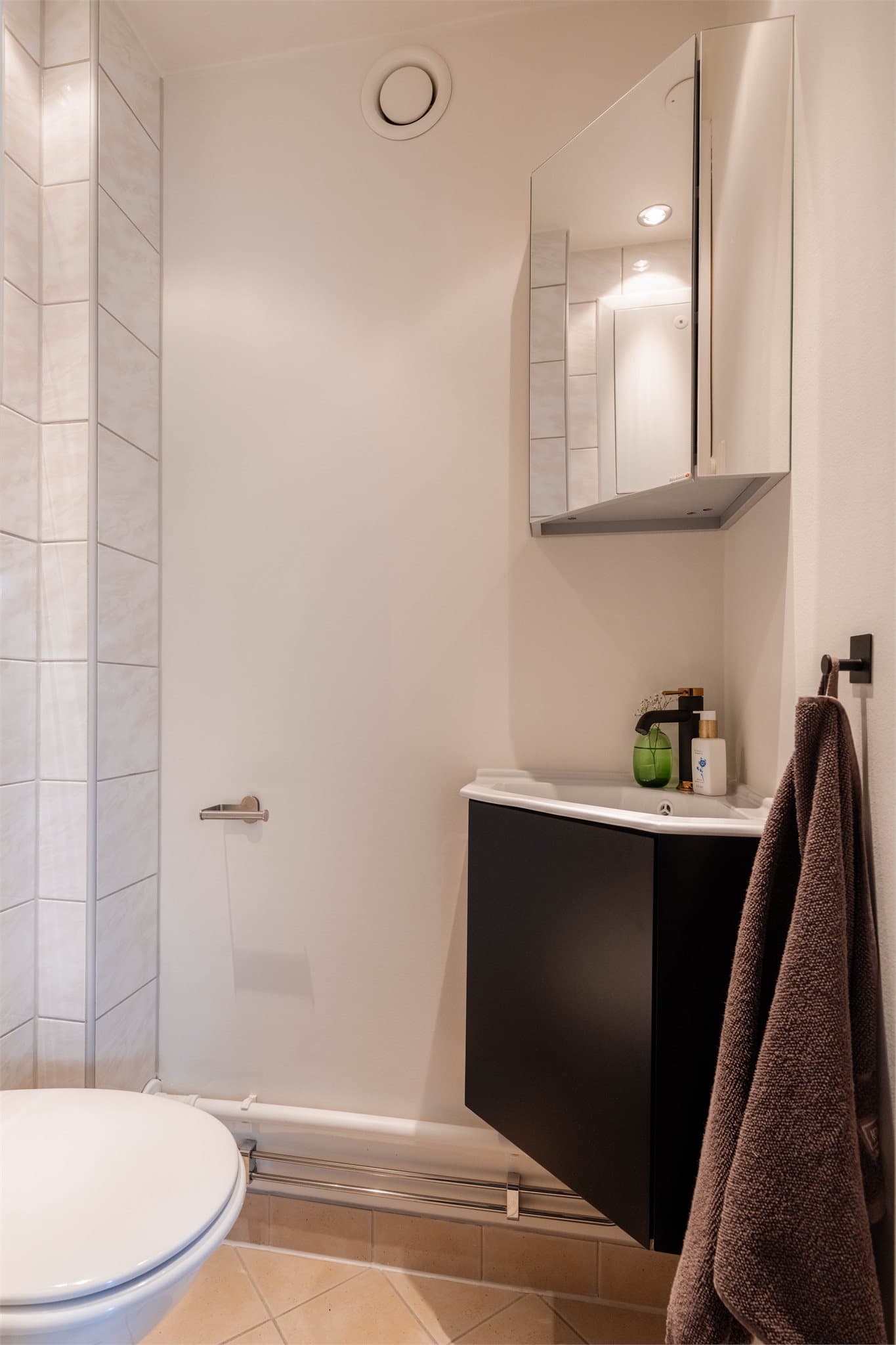 Et praktisk, separat toalettrom som ble rehabilitert i 2011. Rommet har flislagte overflater, toalett med skjult sisterne og en hjørneservant som er ny i 2025.