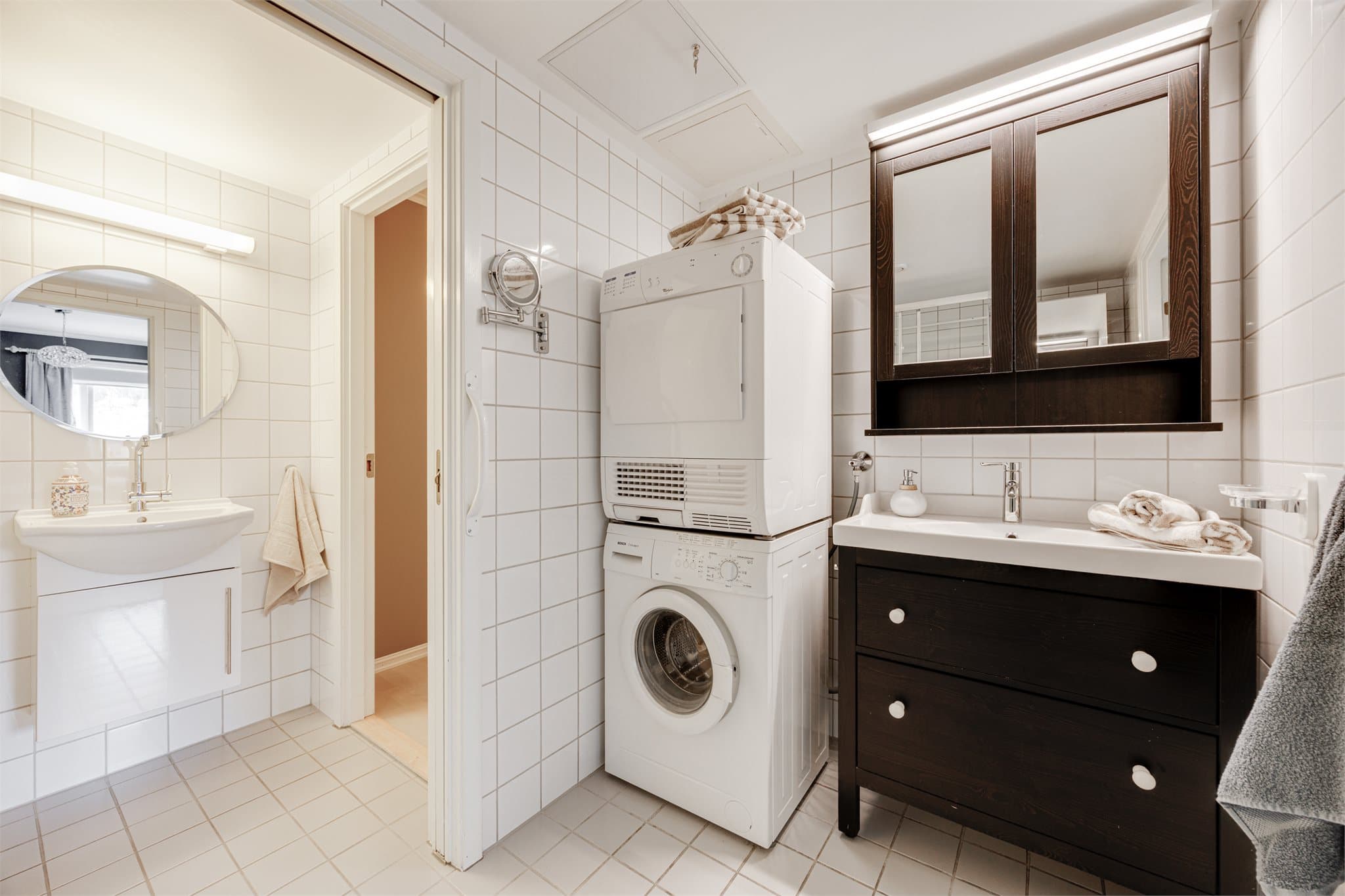 Helfliset baderom innredet med servant med speilskap, dusjkabinett og toalett. Opplegg for vaskemaskin og tørketrommel.