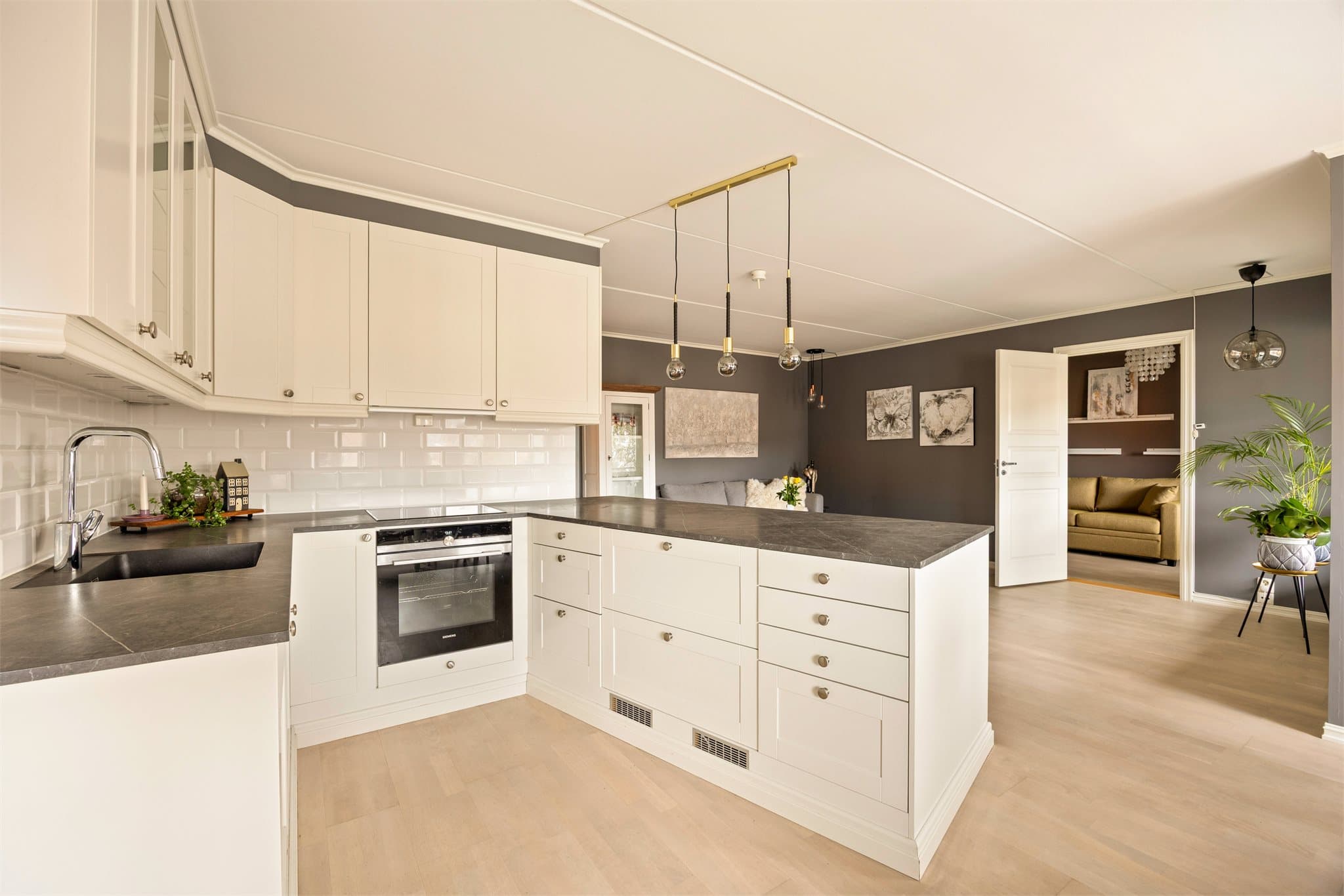 Flott Sigdal-kjøkken med integrert ovn, platetopp, 2 stk kjøleskuffer og oppvaskmaskin.