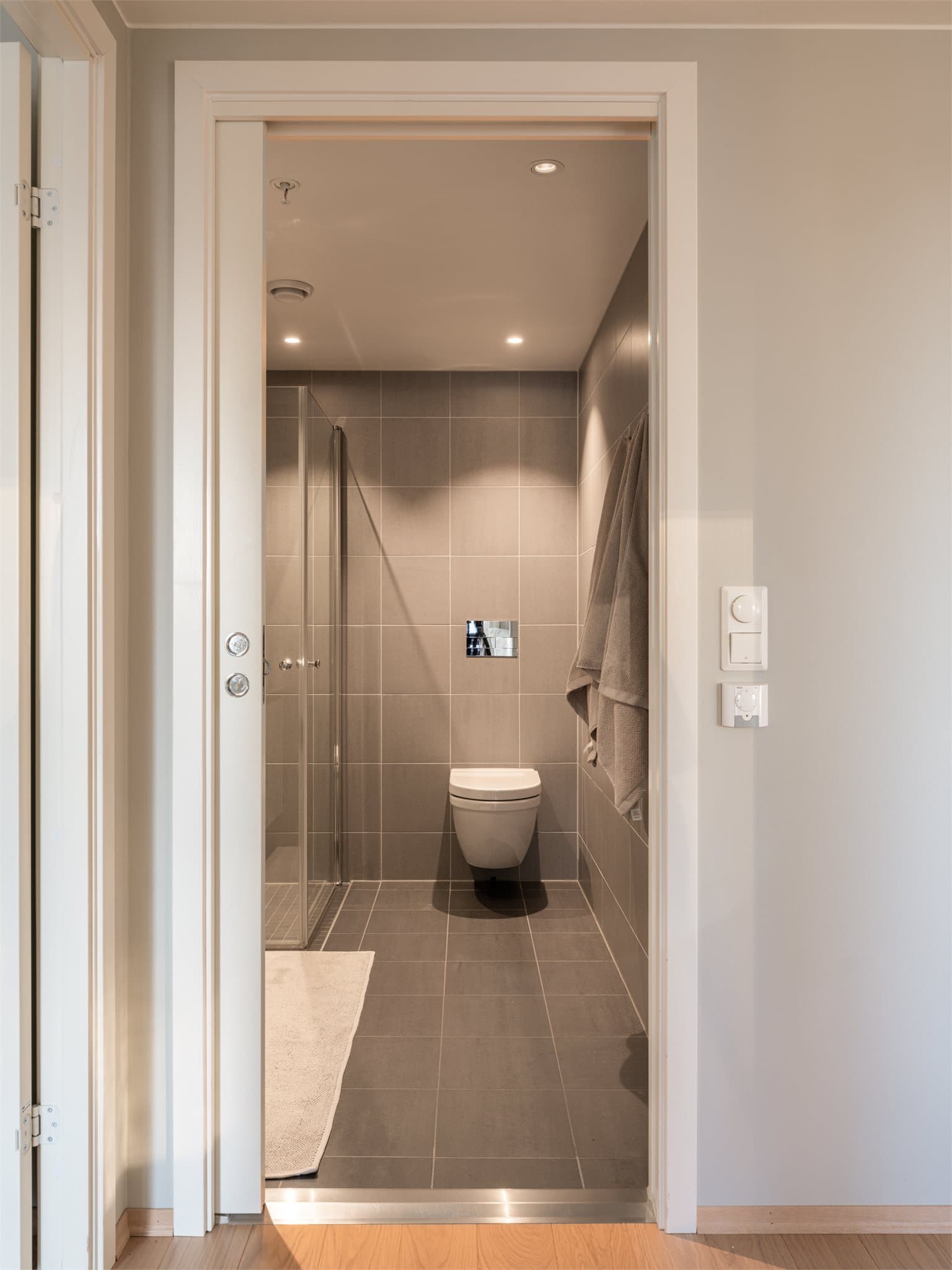 Lekkert, flislagt baderom med vannbåren gulvvarme og innfelte downlights i himlingen.
