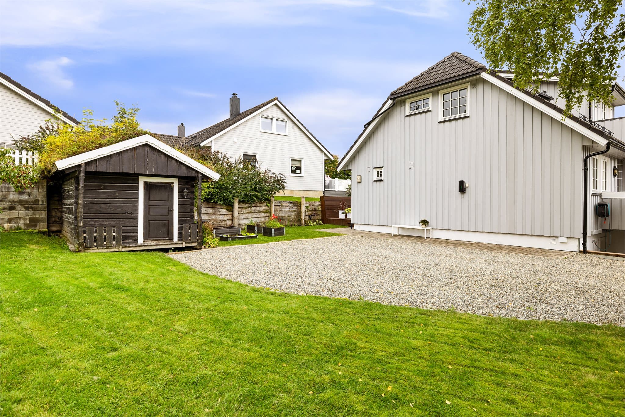 Fin gruslagt gårdsplass med gode parkeringsmuligheter.
