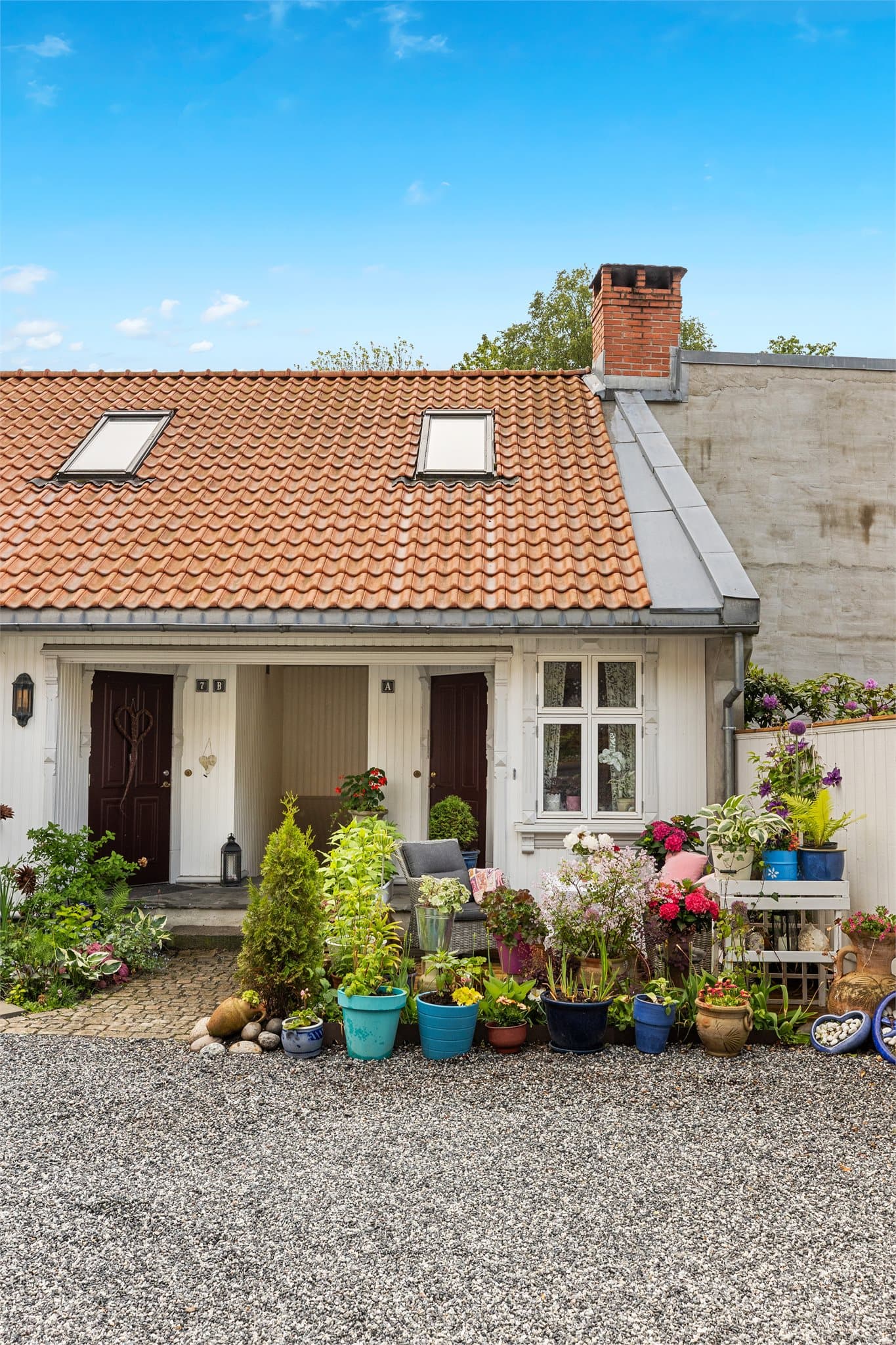 En sjarmerende uteplass ved inngangspartiet gir en privat sone for uteliv og trivsel.