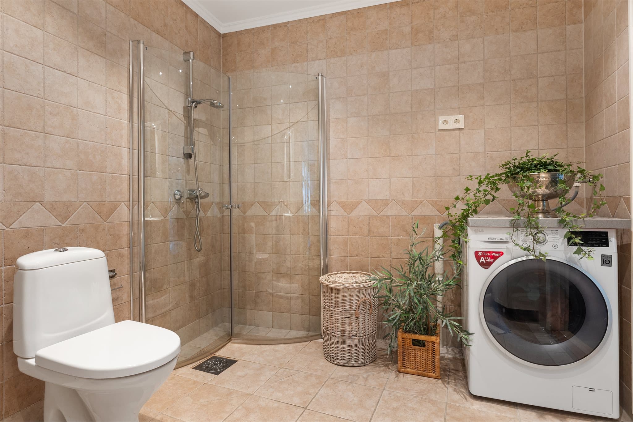 Badet er praktisk kombinert med vaskerom, med opplegg for vaskemaskin.