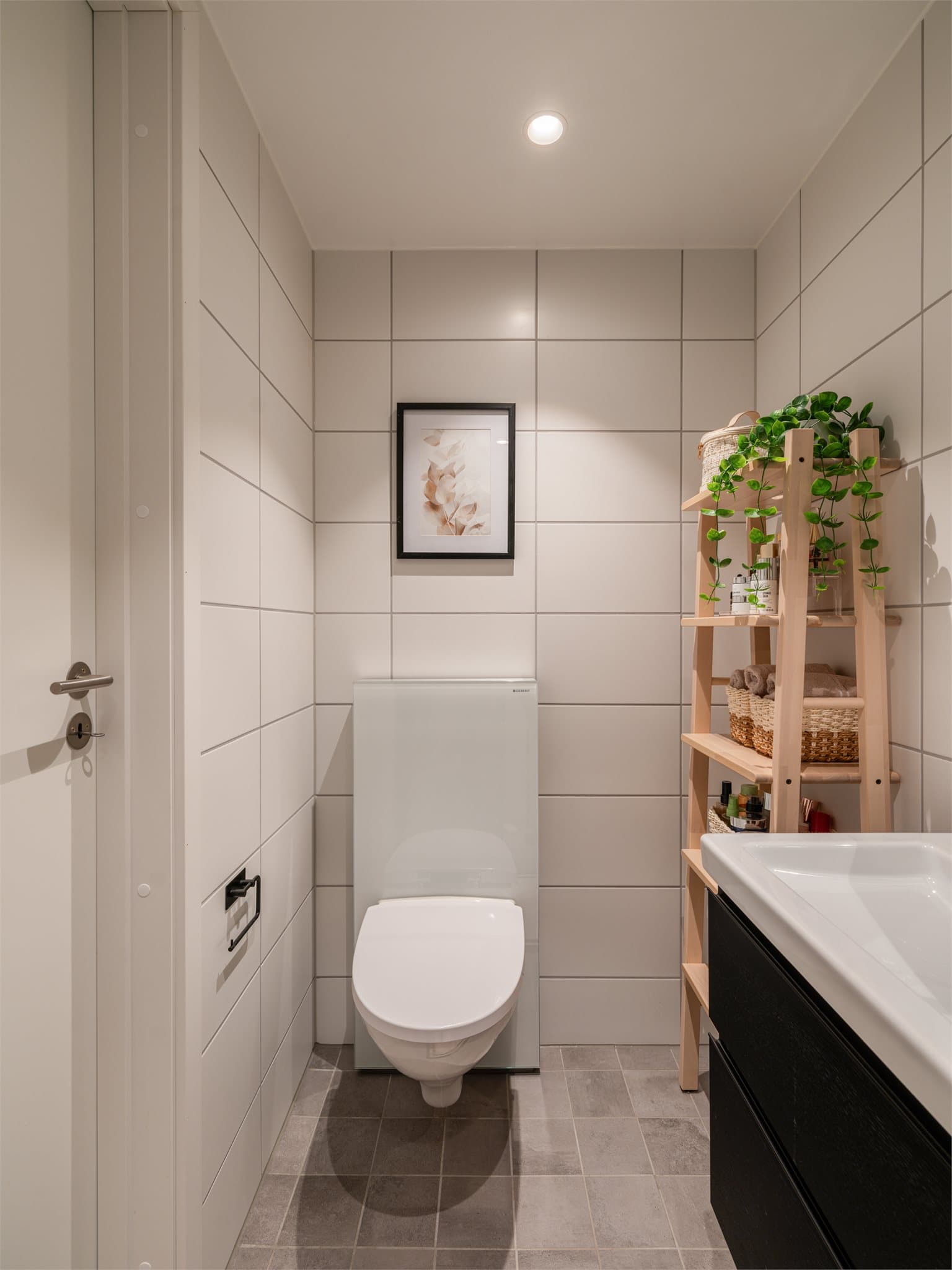 Badet har vegghengt toalett og plass til praktiske oppbevaringsløsninger.