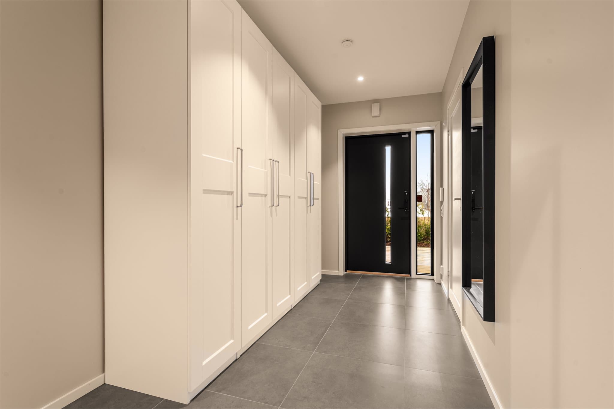 Entré/gang med fliser og varme i gulv samt stort garderobeskap. Det er i tillegg egen, direkte inngang fra dobbeltgarasjen