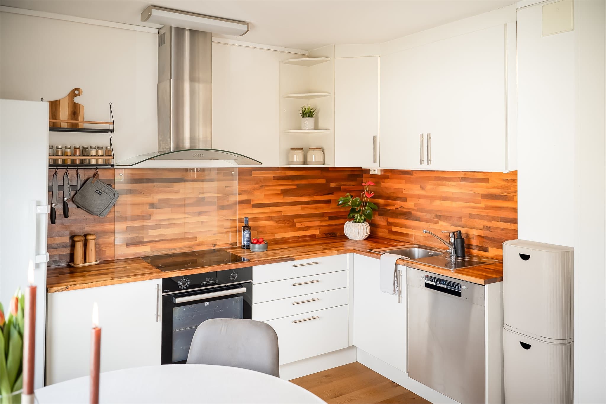 Lyst kjøkken i egen sone, smart utformet med praktisk vinkelløsning og med oppbevaringsplass i både over- og underskap.