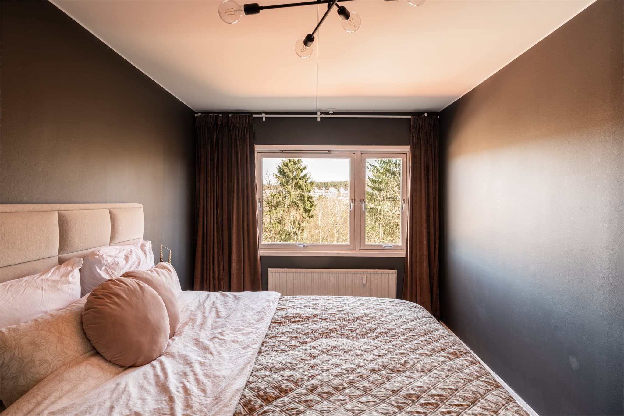 Romslig hovedsoverom med god plass til en stor dobbeltseng med nattbord på sidene.