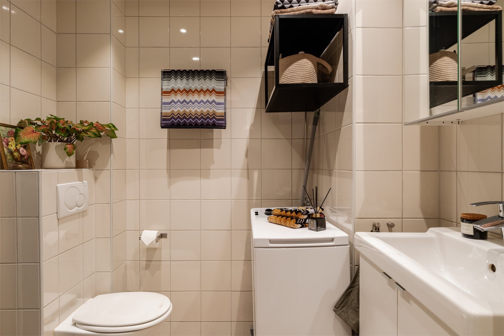 Flislagt bad med elektrisk gulvvarme og opplegg for vaskemaskin. Innredningen er fra 2018.
