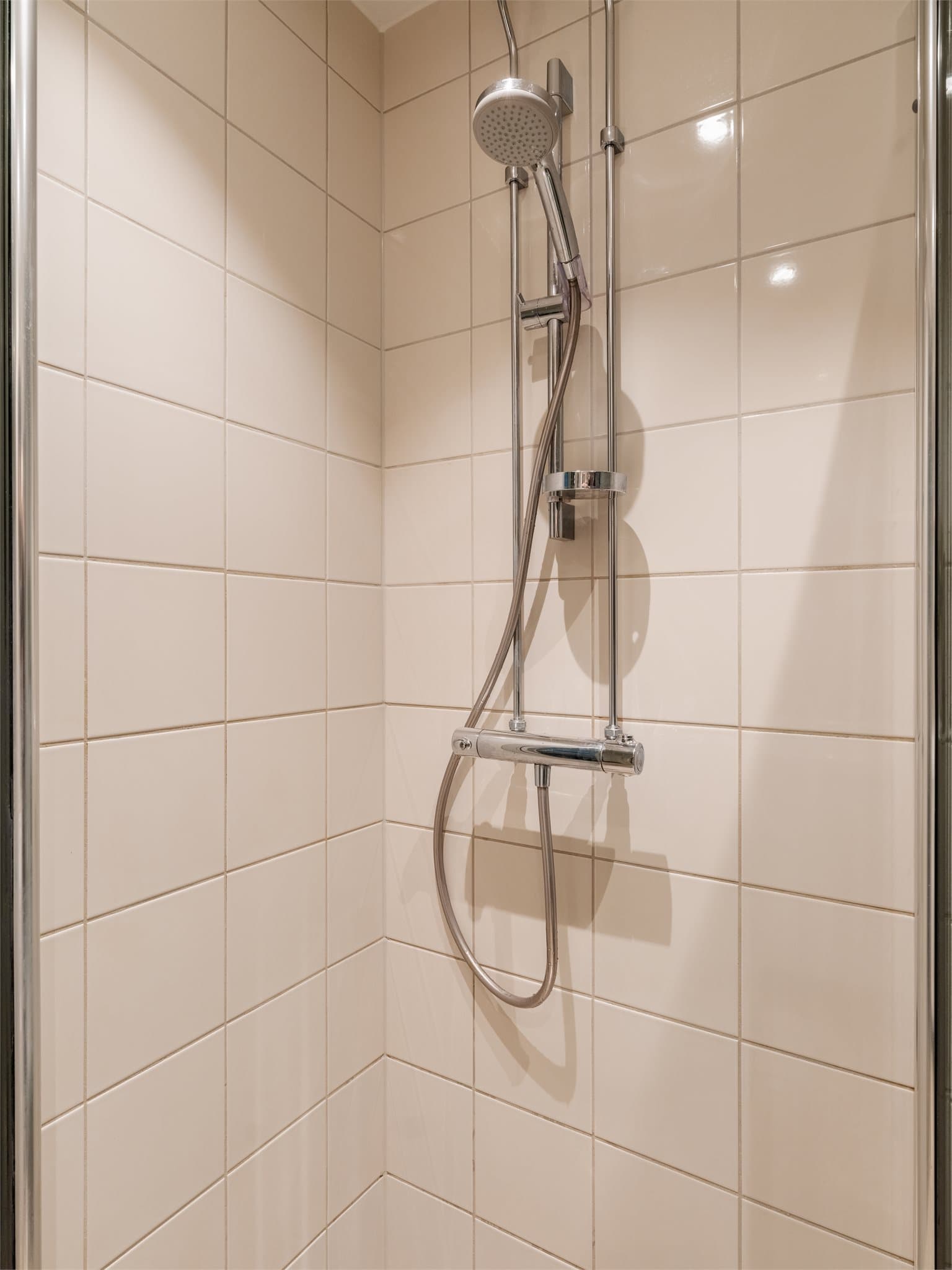 Dusjhjørne med svingbare glassdører. Badet ble pusset opp i 2010.