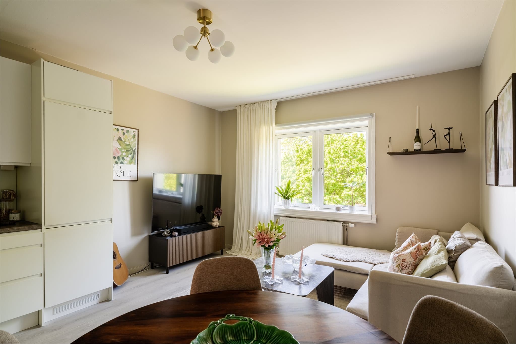 Stuen har plass til både sofagruppe og spisebord. Overflatene er fra 2017-2020, med laminatgulv og malte vegger.