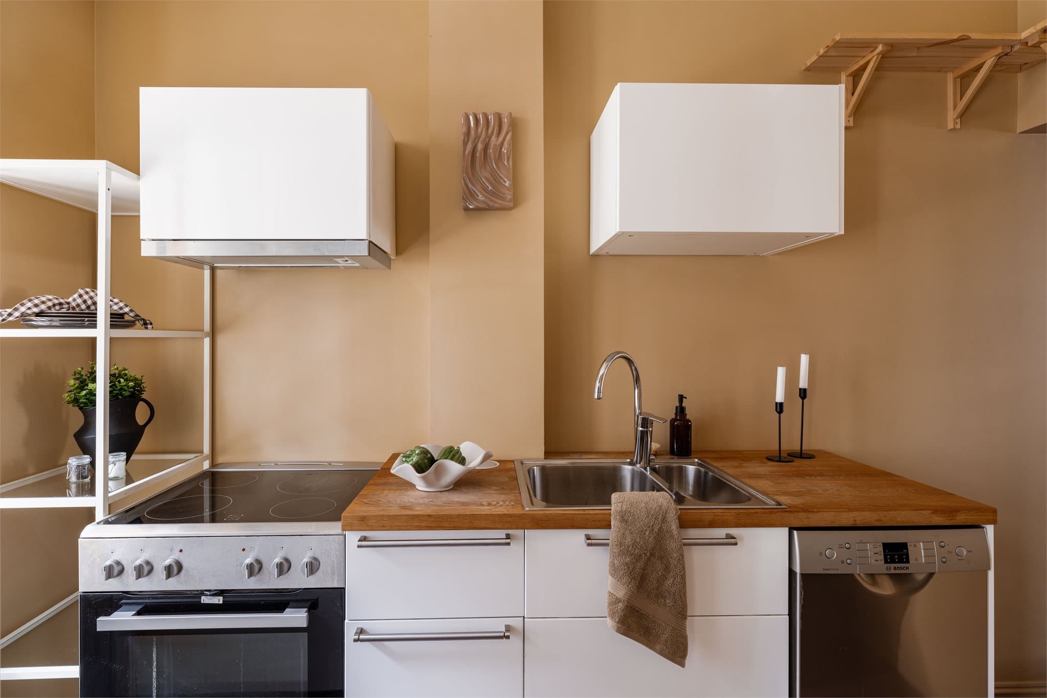 Kjøkkenet har en benkeplate i treverk og innredning med glatte fronter.