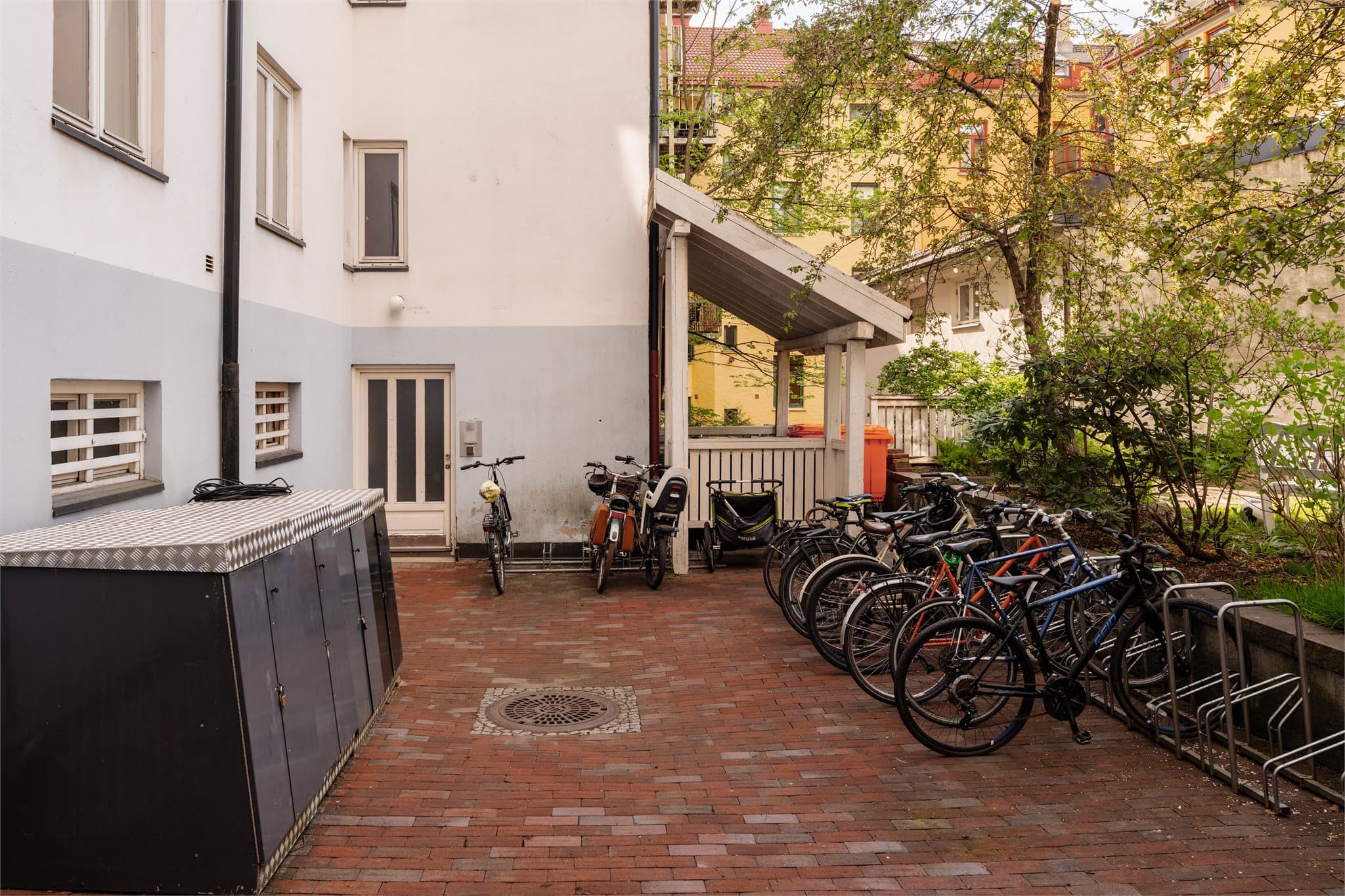 Aksjelaget har en hyggelig og pent opparbeidet bakgård med sykkelparkering.