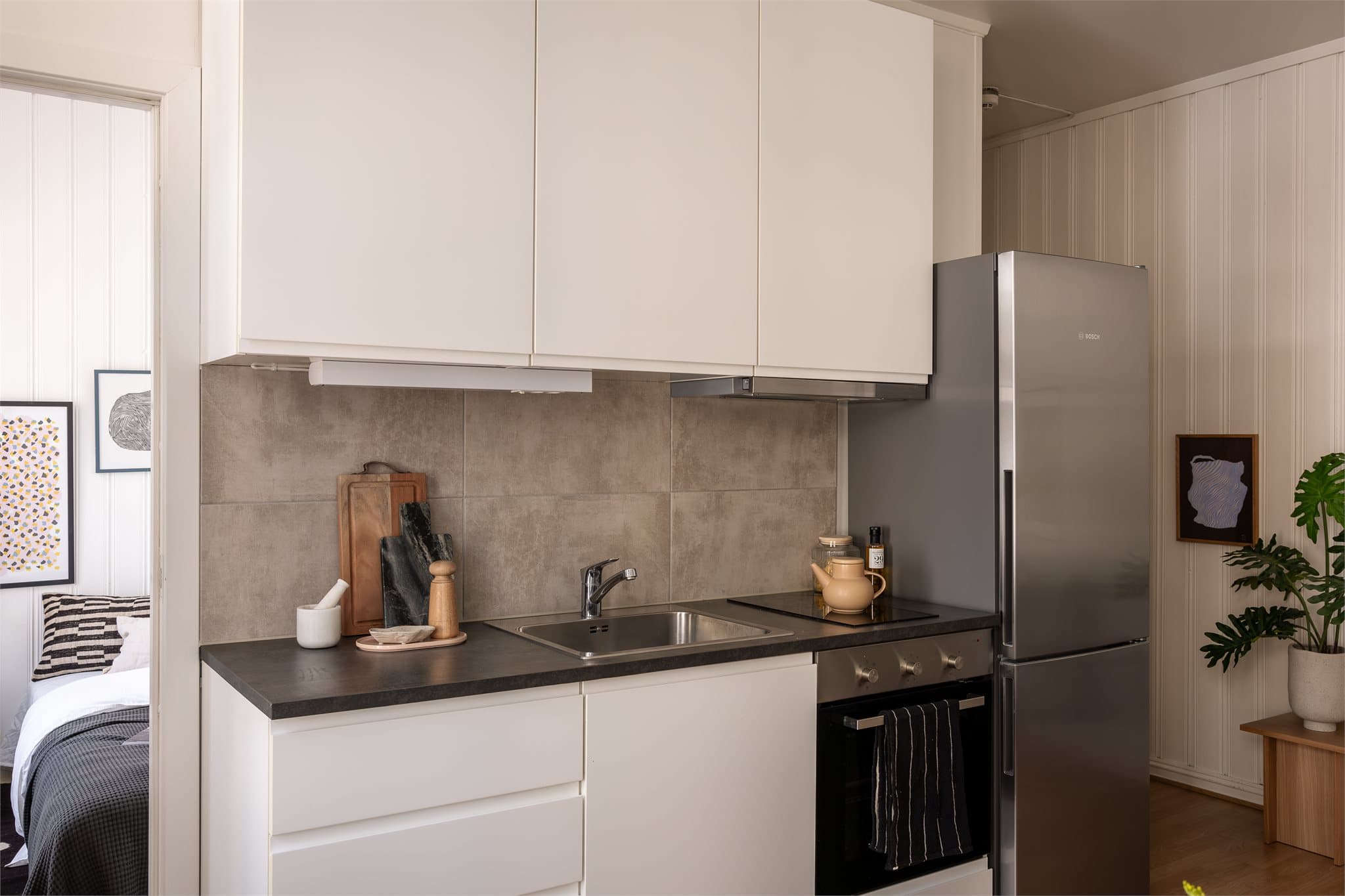 Kjøkkenet har lyse slette fronter og laminat benkeplate. Det er god skapplass til størrelsen å være.