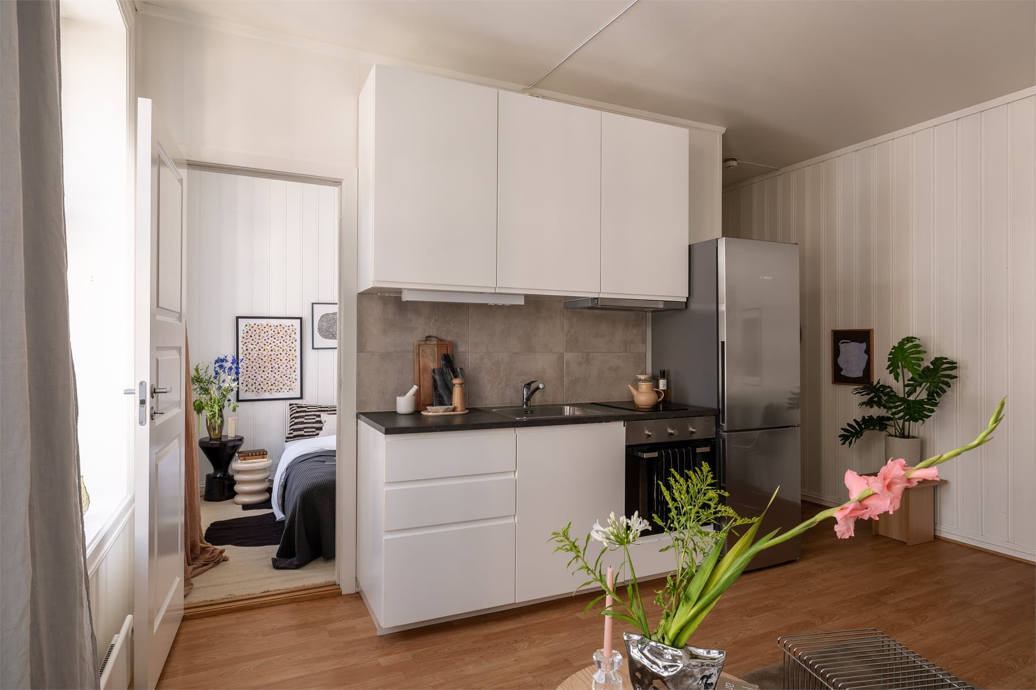 Et lyst og delikat kjøkken med integrerte hvitevarer som stekeovn, platetopp og oppvaskmaskin. Det er i tillegg frittstående kjøl-/fryseskap.
