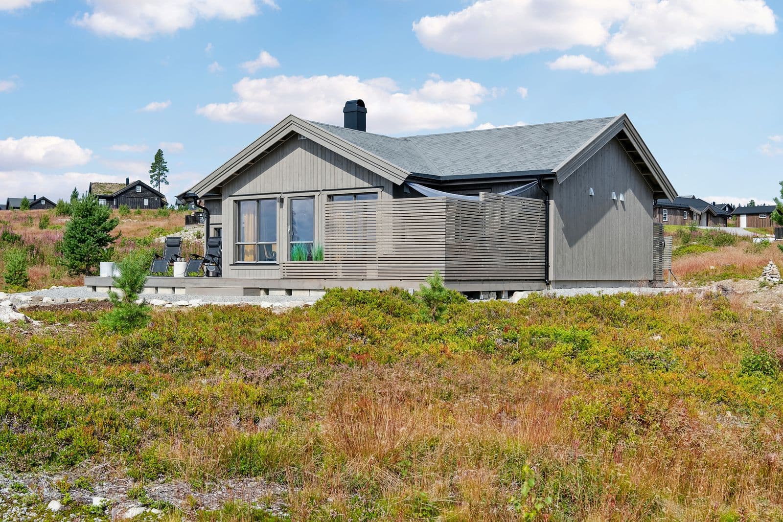 Solrik terrasse mot syd/vest med moderne spilevegger som gir en lun og usjenert uteplass. Det er god plass til flere sittegrupper, grill og møblering i ulike soner av uterommet.