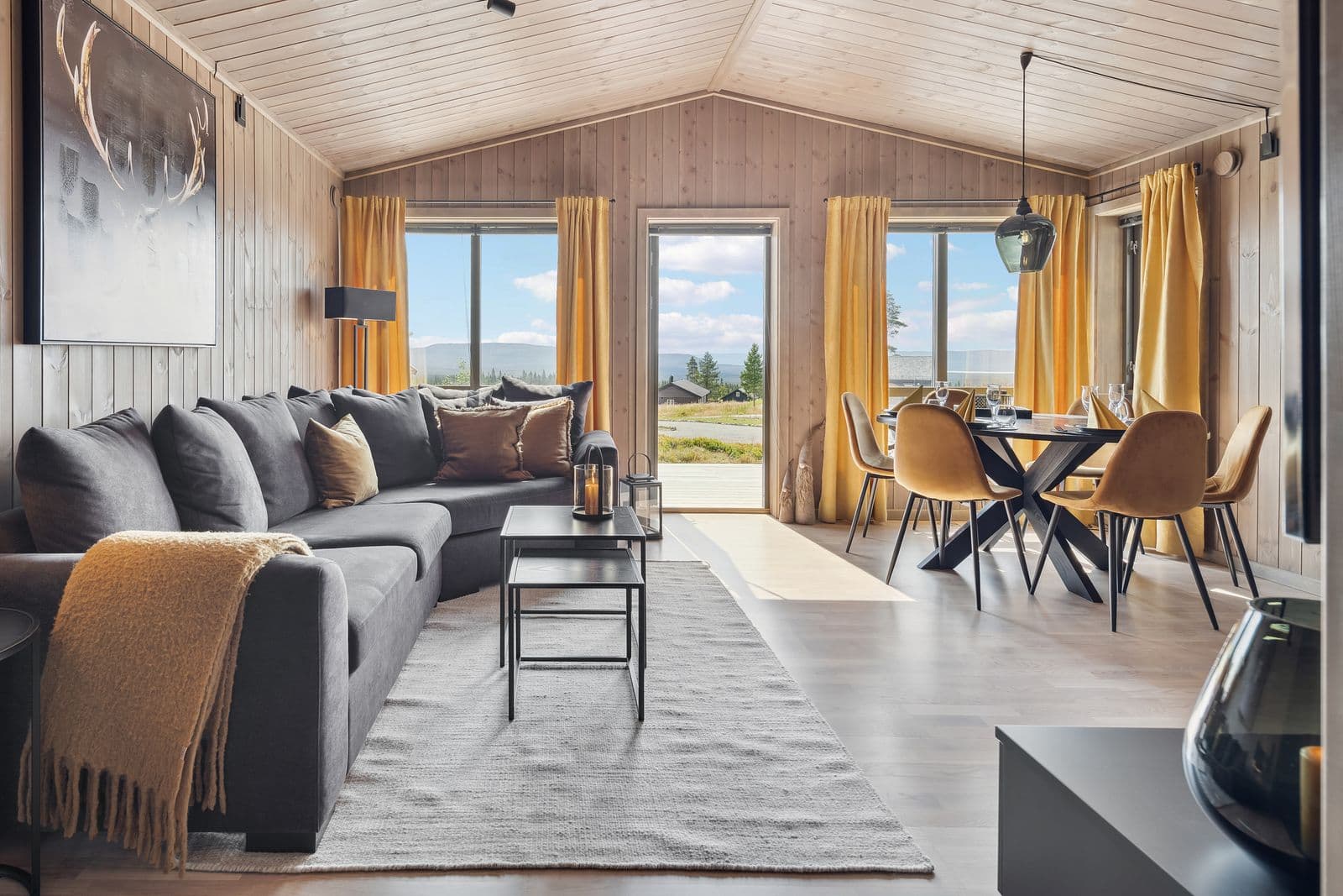 Når du trår inn i hytta, møtes du av en åpen og innbydende stue- og kjøkkenløsning som umiddelbart skaper en romslig og sosial atmosfære. De store vindusflatene slipper inn rikelig med naturlig lys og gir en herlig følelse av nærhet til naturen utenfor.