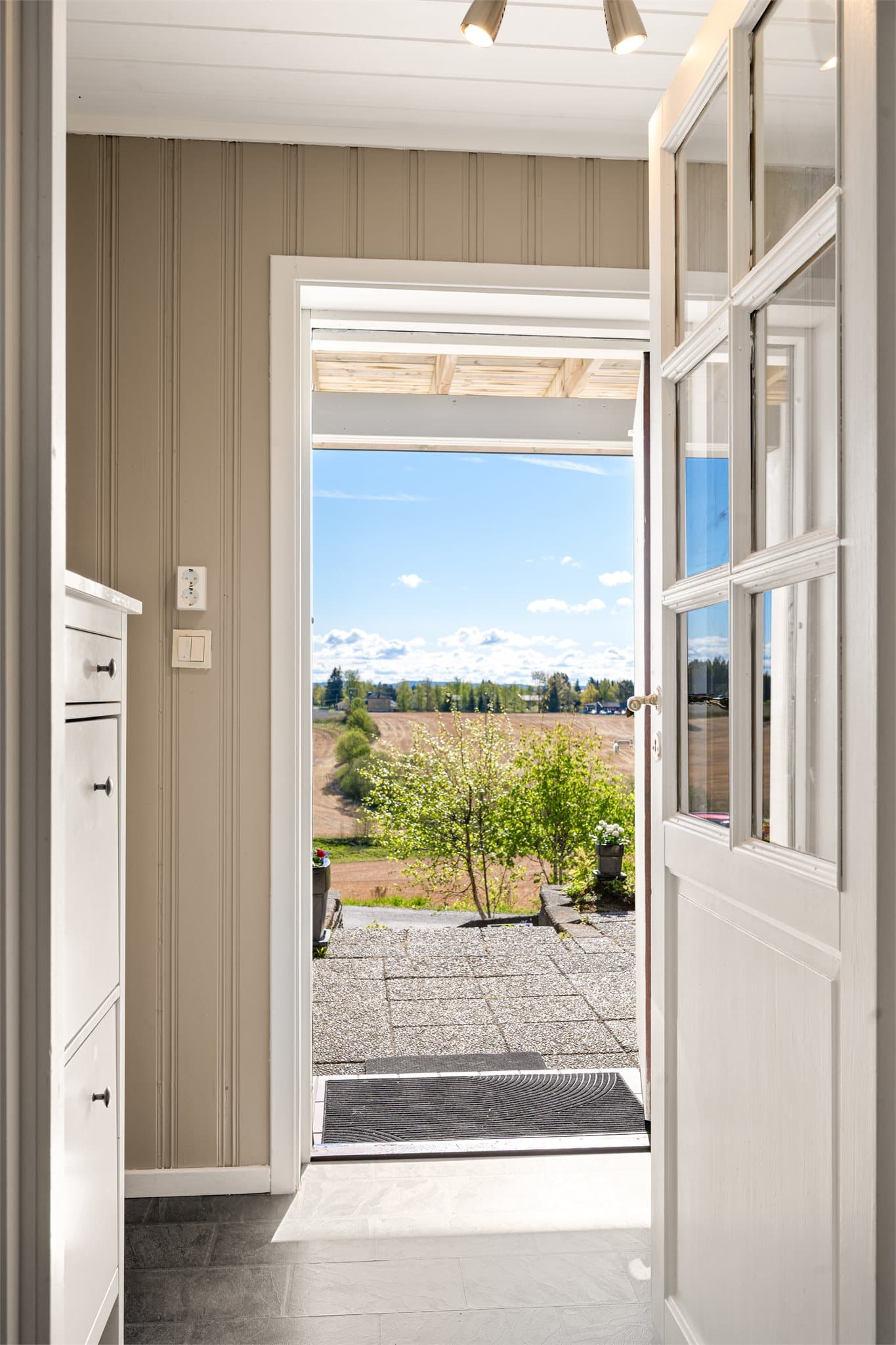 Velkommen inn! Døren med glassfelt inn mot mellomgangen slipper lyset videre inn i boligen og skaper en luftig og innbydende entré.