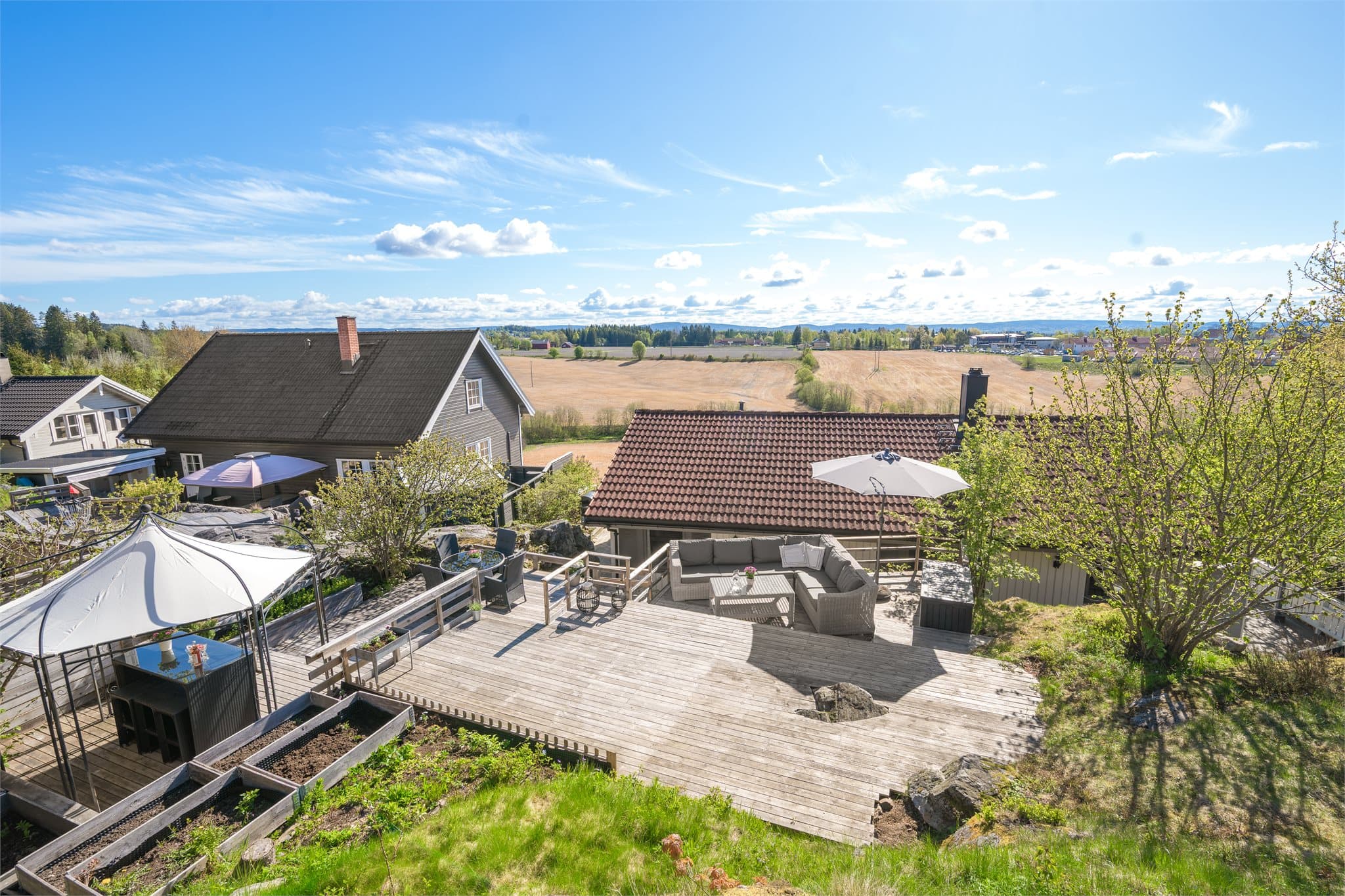 Den flotte naturtomten med fjell i dagen gir uteområdet et særpreget og idyllisk uttrykk, mens de ulike terrasseområdene skaper fine soner for både rekreasjon og sosialt samvær.