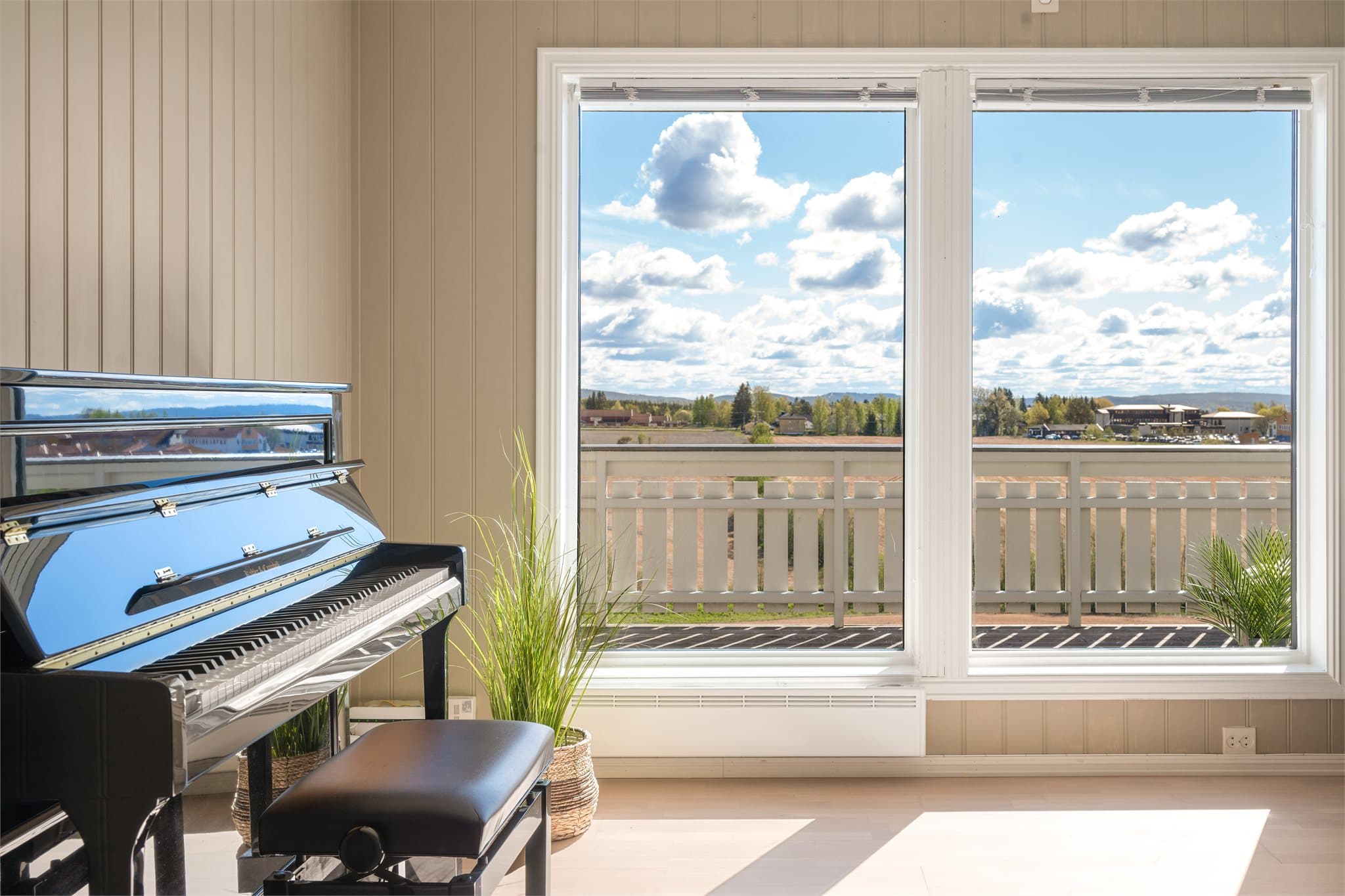 De store stuevinduene gir en fantastisk kontakt med omgivelsene og slipper naturen helt inn i oppholdsrommet. Utsynet over det åpne landskapet skaper en rolig og harmonisk atmosfære som gjør stuen til et naturlig sted å senke skuldrene.