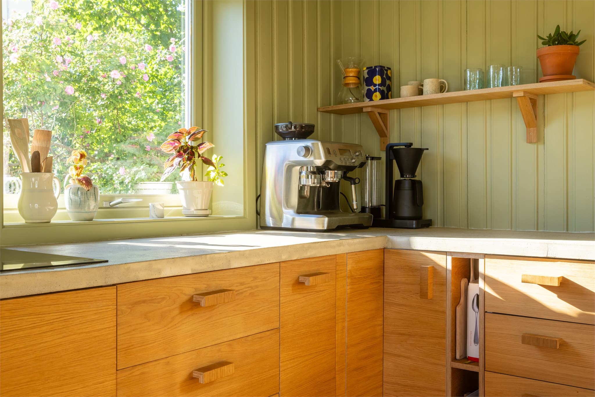 Innredningen er utført med Ikea-skrog kombinert med fronter i eikefiner, som gir et varmt preg, mens helstøpt benkeplate i betong tilfører et moderne uttrykk og solide arbeidsflater.