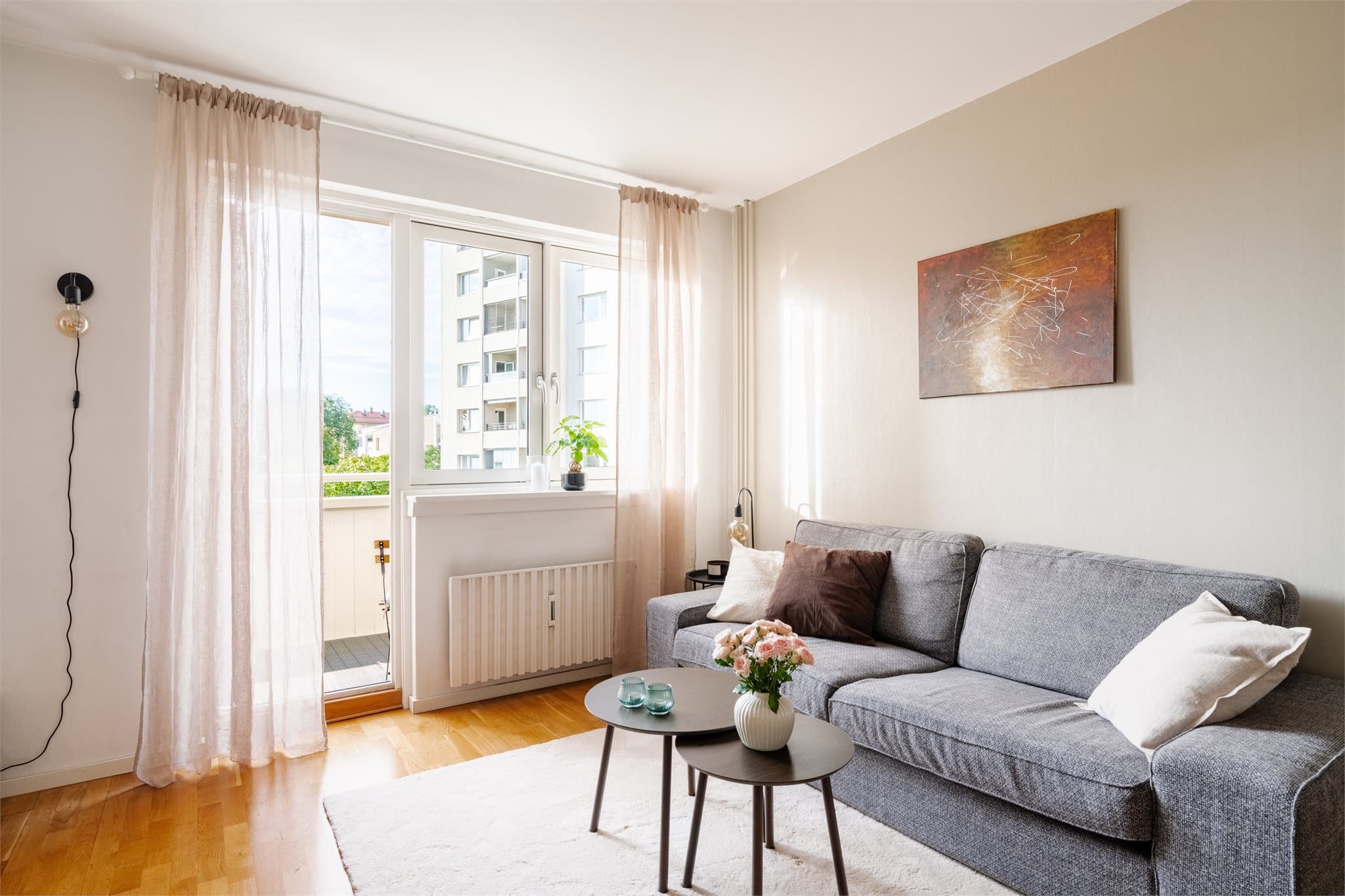 Sofagruppen har god plass, med balkongdør som slipper inn lys og luft.