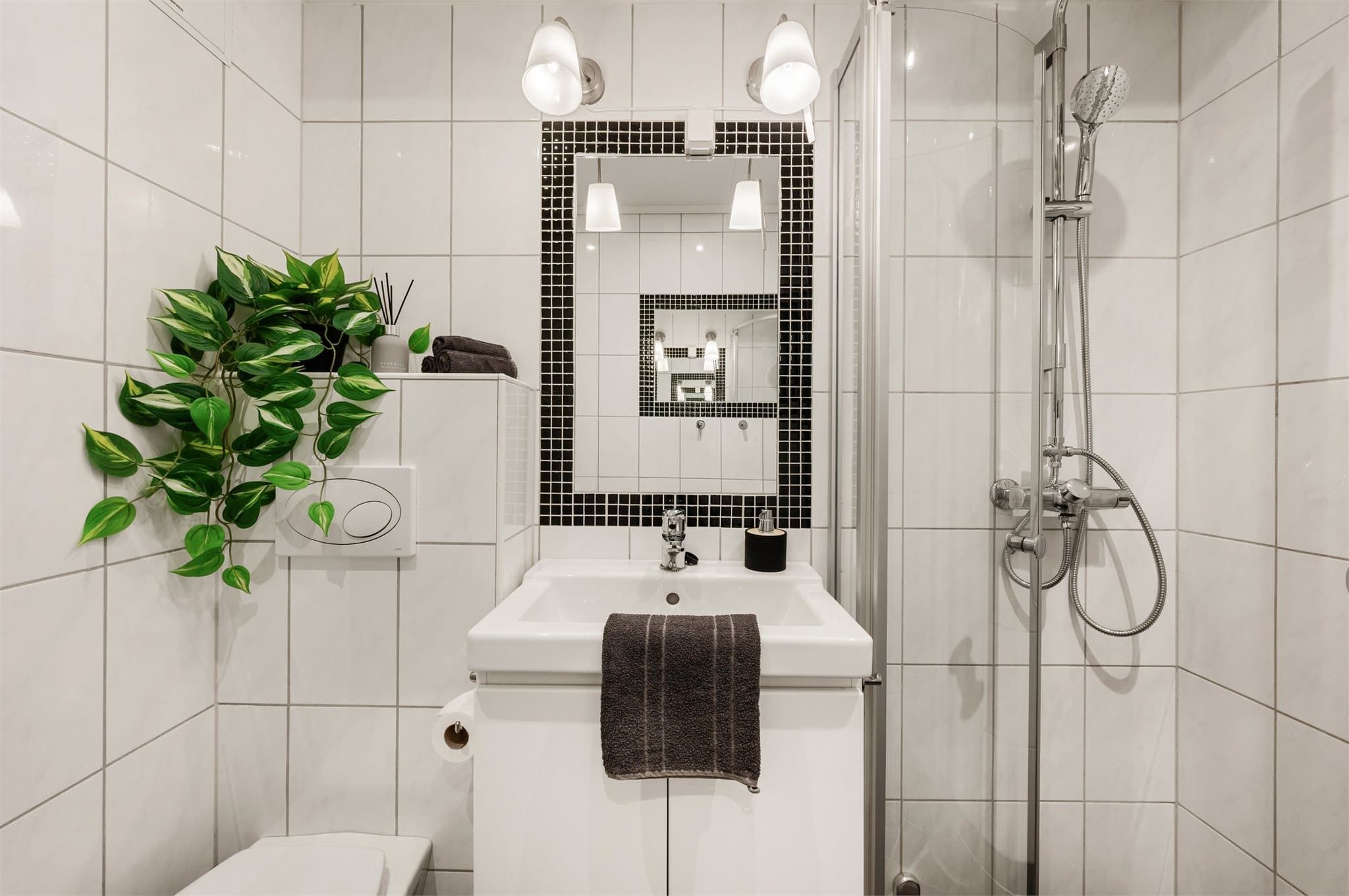 - Badet er innredet med vegghengt toalett, heldekkende servant og dusjhjørne -