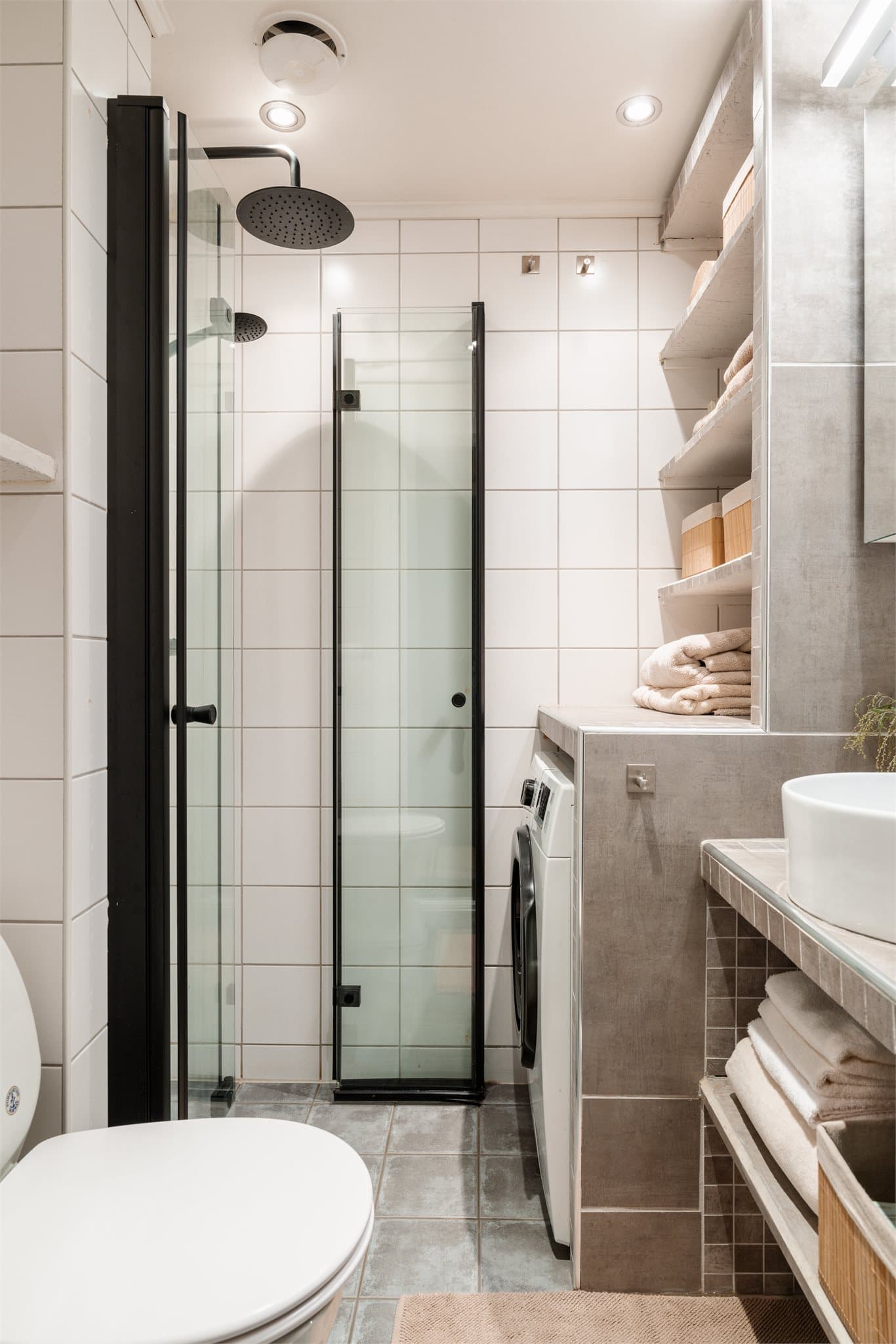 Innredningen består bl.a. av en flislagt benk med frittstående servant og et vegghengt toalett.