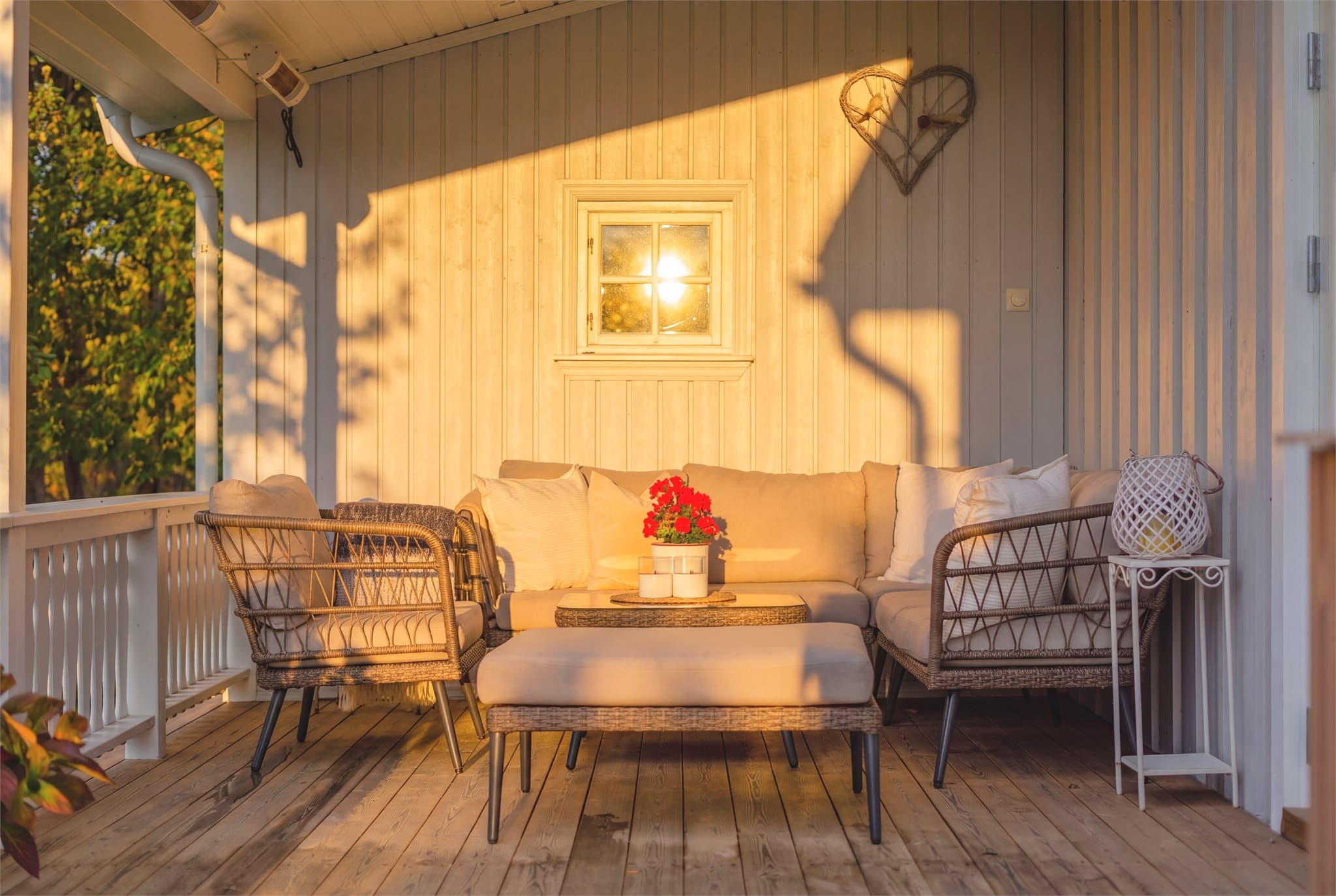 Overbygget terrasse med hvitmalt trepanel og sitteplass. Bilde er digitalt redigert med KI-verktøy for inspirasjon og stemning. Avvik kan derfor forekomme