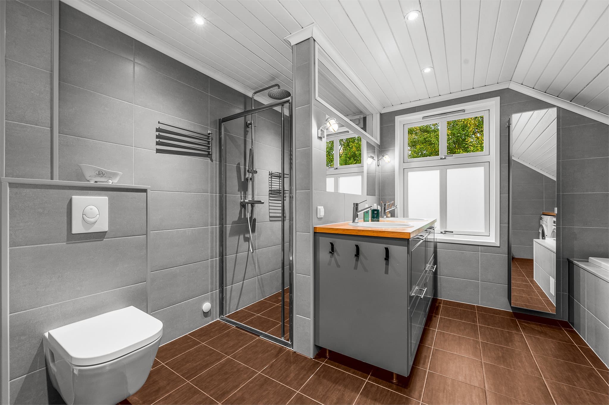 Badet i 2. etasje har flislagte vegger, varmekabler i gulv, dusjhjørne og innredning fra 2014.