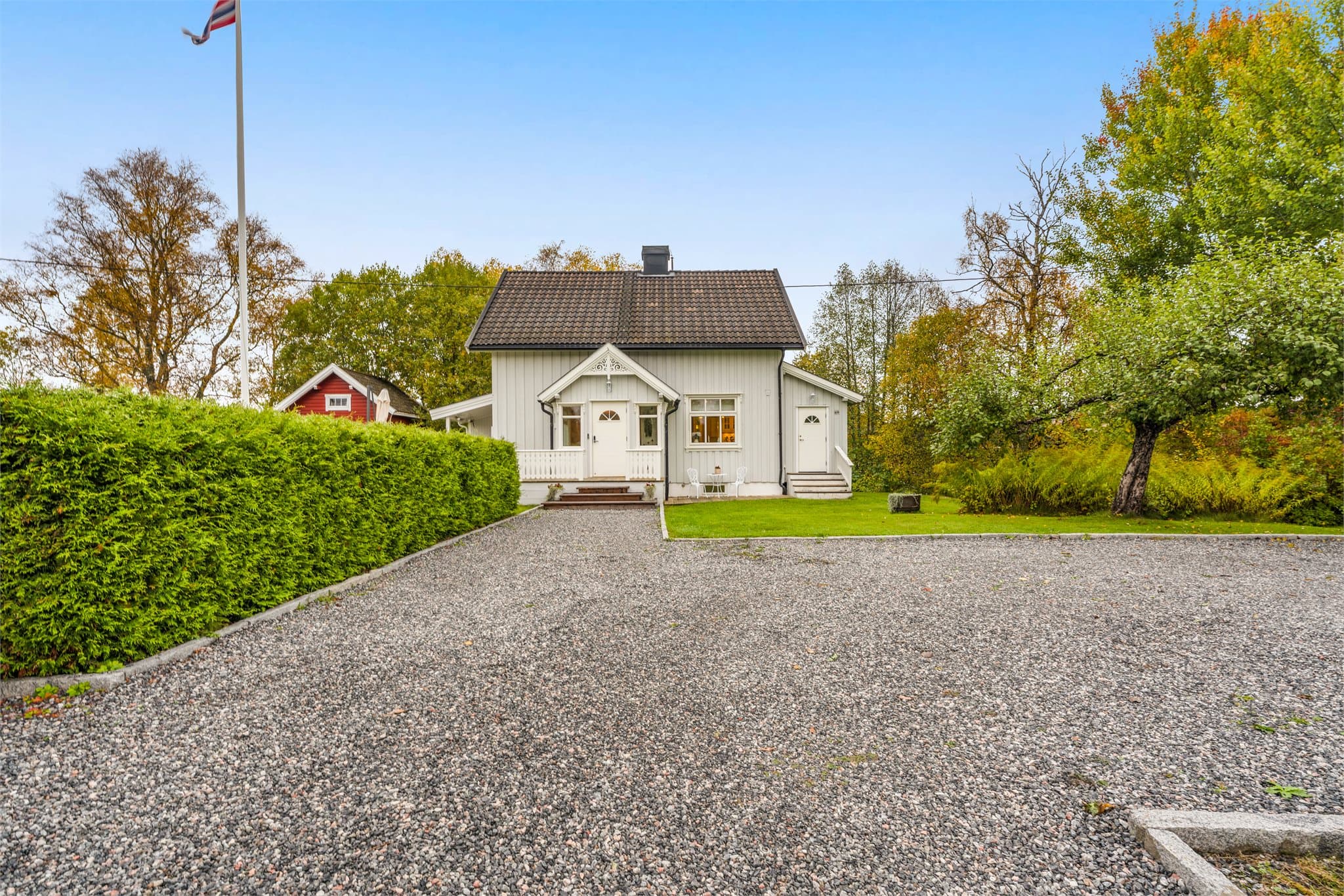 Gruset innkjøring og gårdsplass foran boligen.