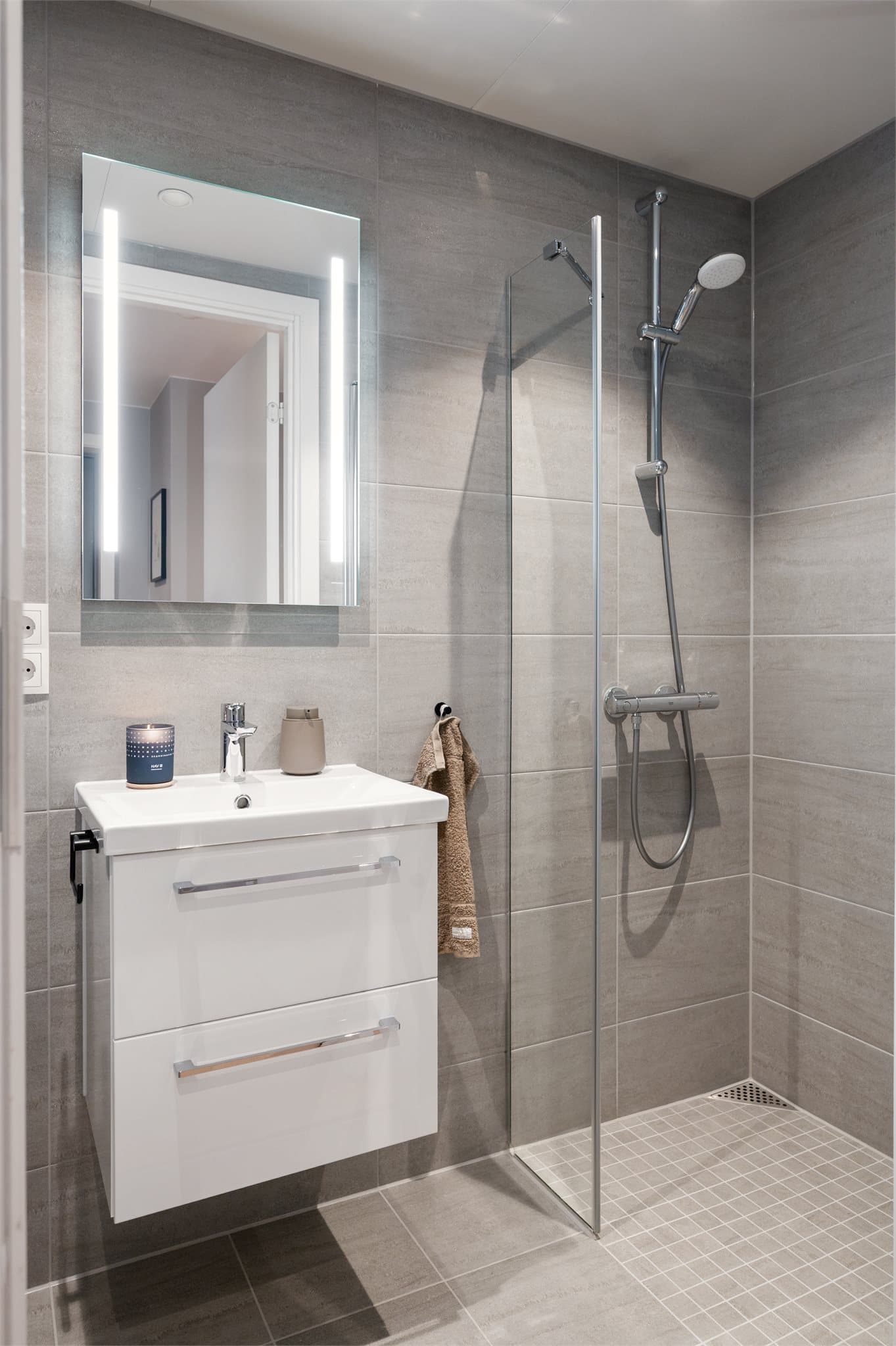 Utstyrt med dusjhjørne med svingdører, håndholdt dusj og veggmontert toalett.