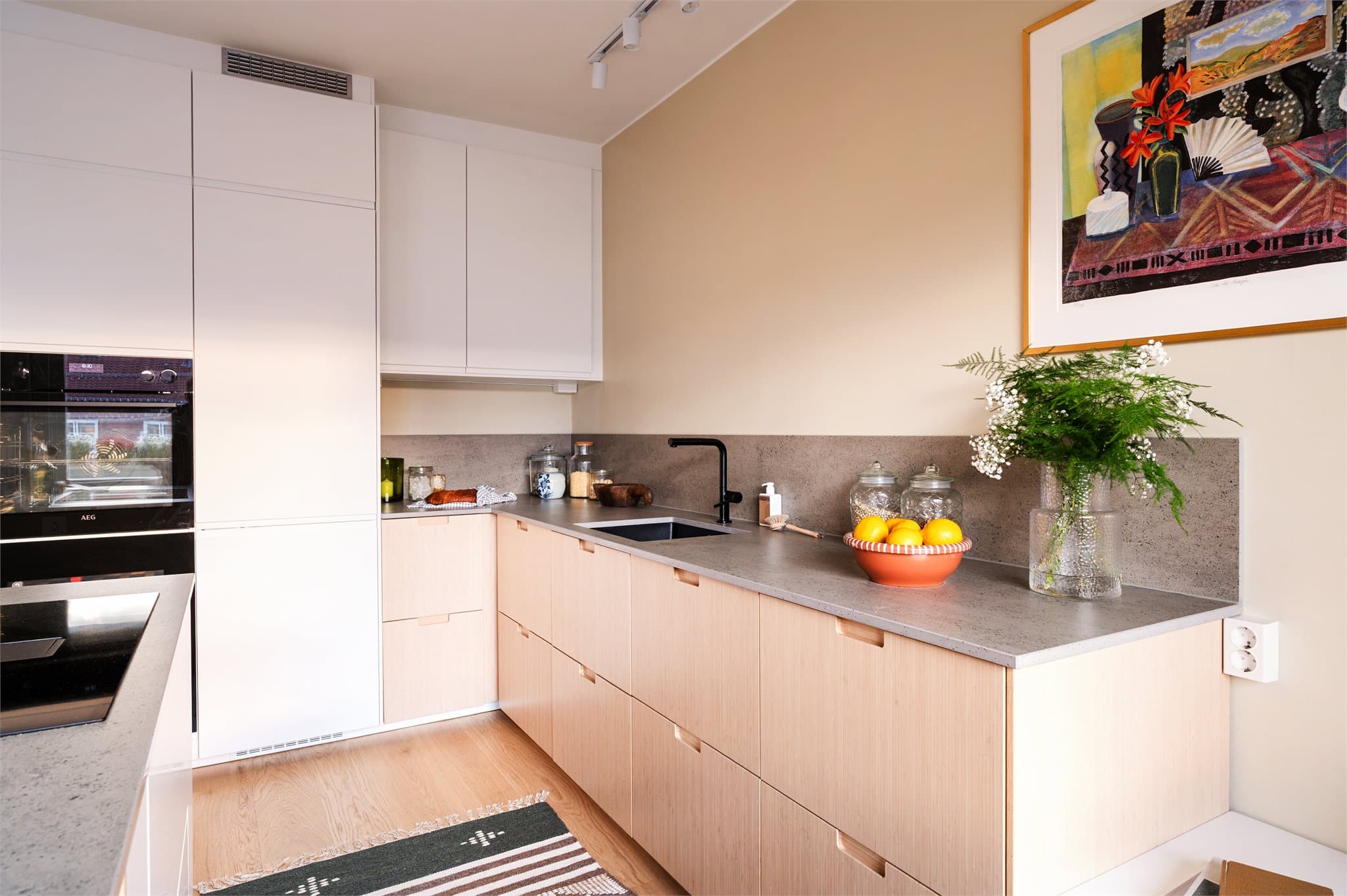 Kombinasjonen av lyse flater og varme tretoner skaper et rom som føles både tidløst og innbydende.