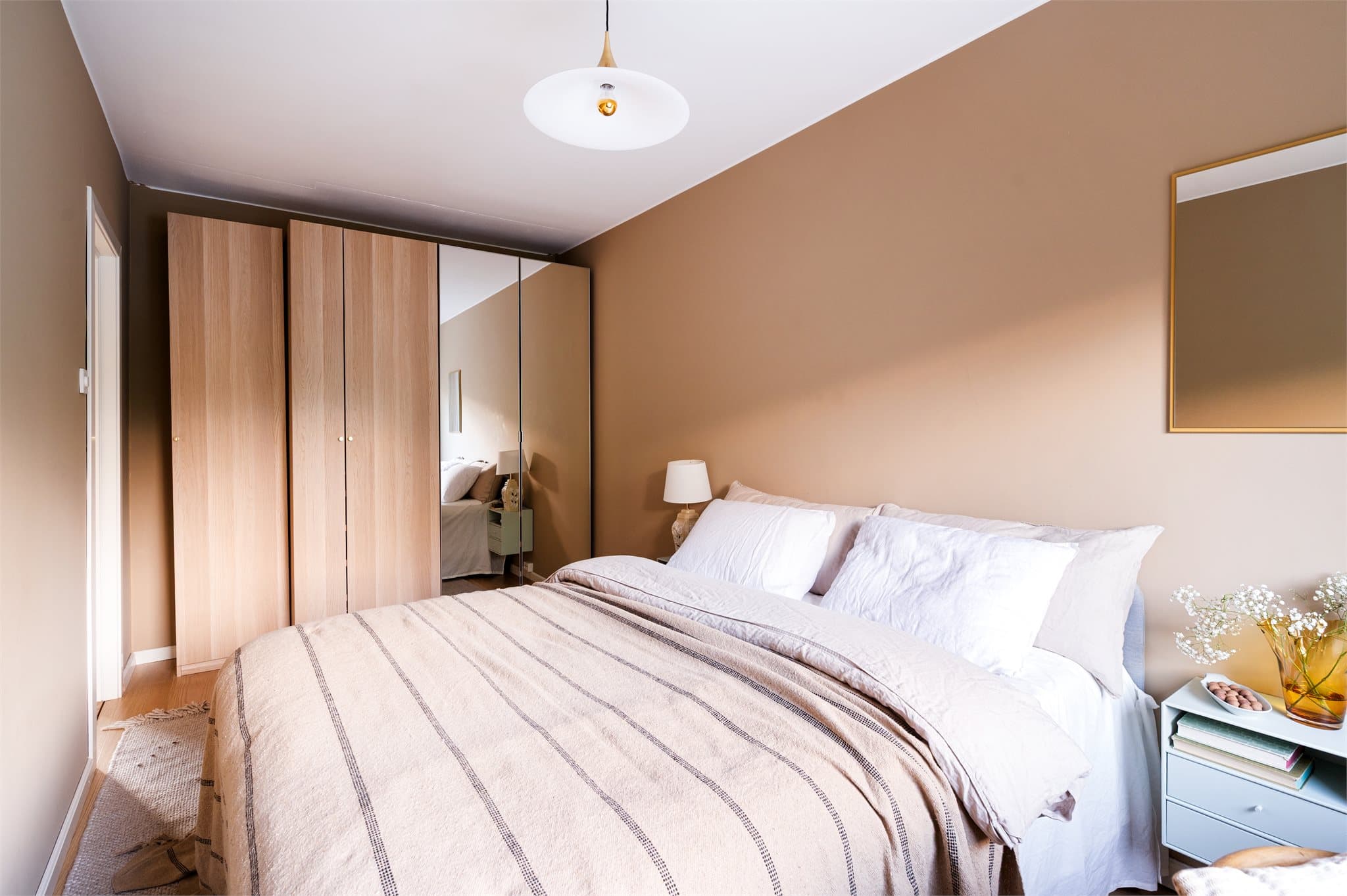 Hovedsoverom med romslig planløsning som rommer dobbeltseng, garderobe, nattbord og arbeidsområde.