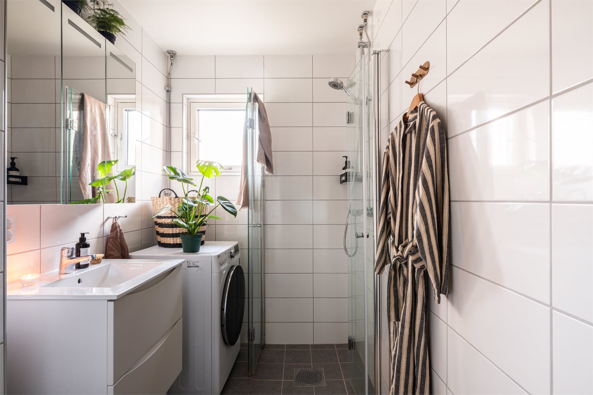 Badet er utstyrt med dusjhjørne med innfellbare dører og opplegg for vaskemaskin.