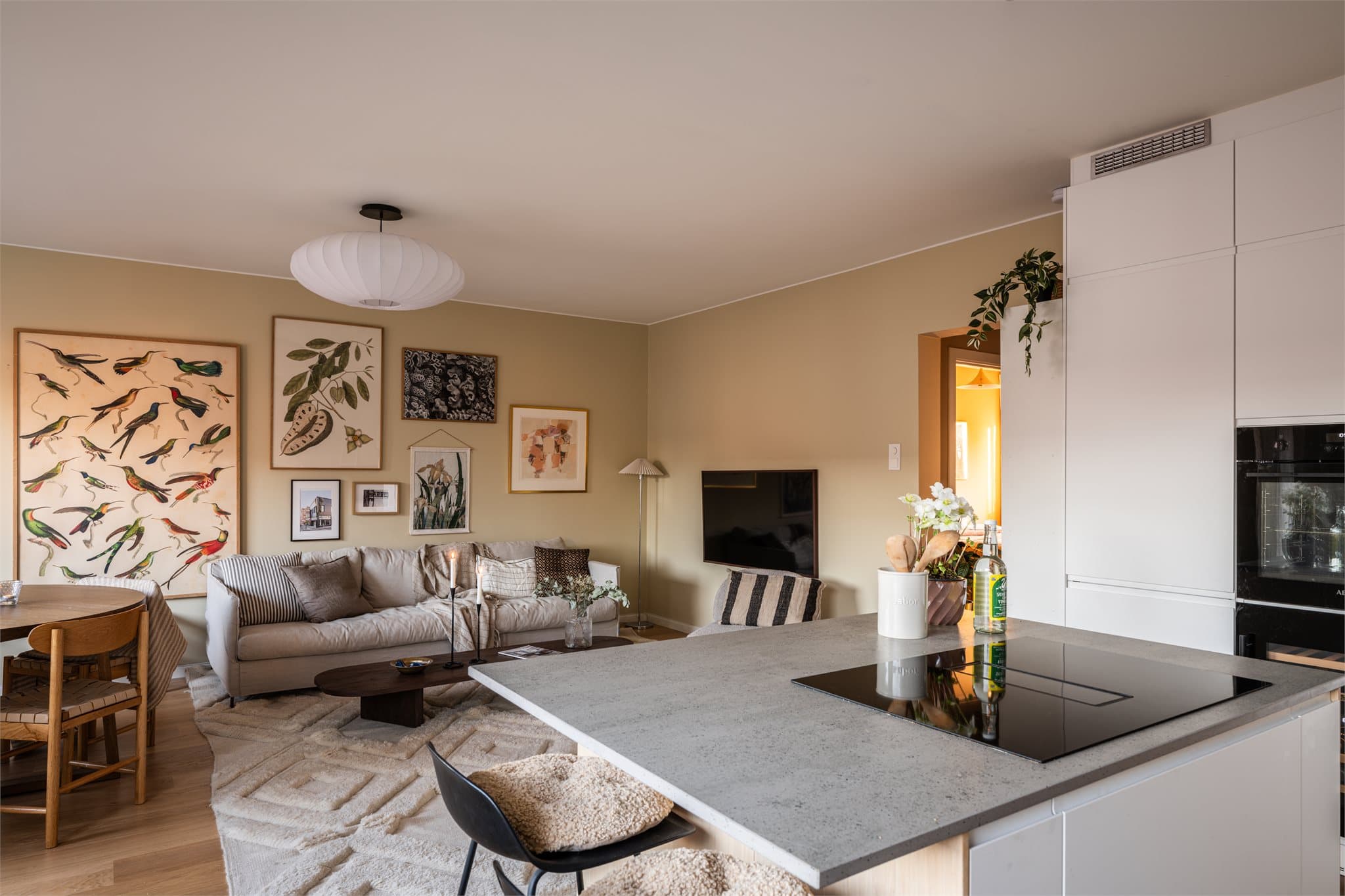 Åpen løsning mellom stue og kjøkken skaper en luftig og sosial atmosfære.