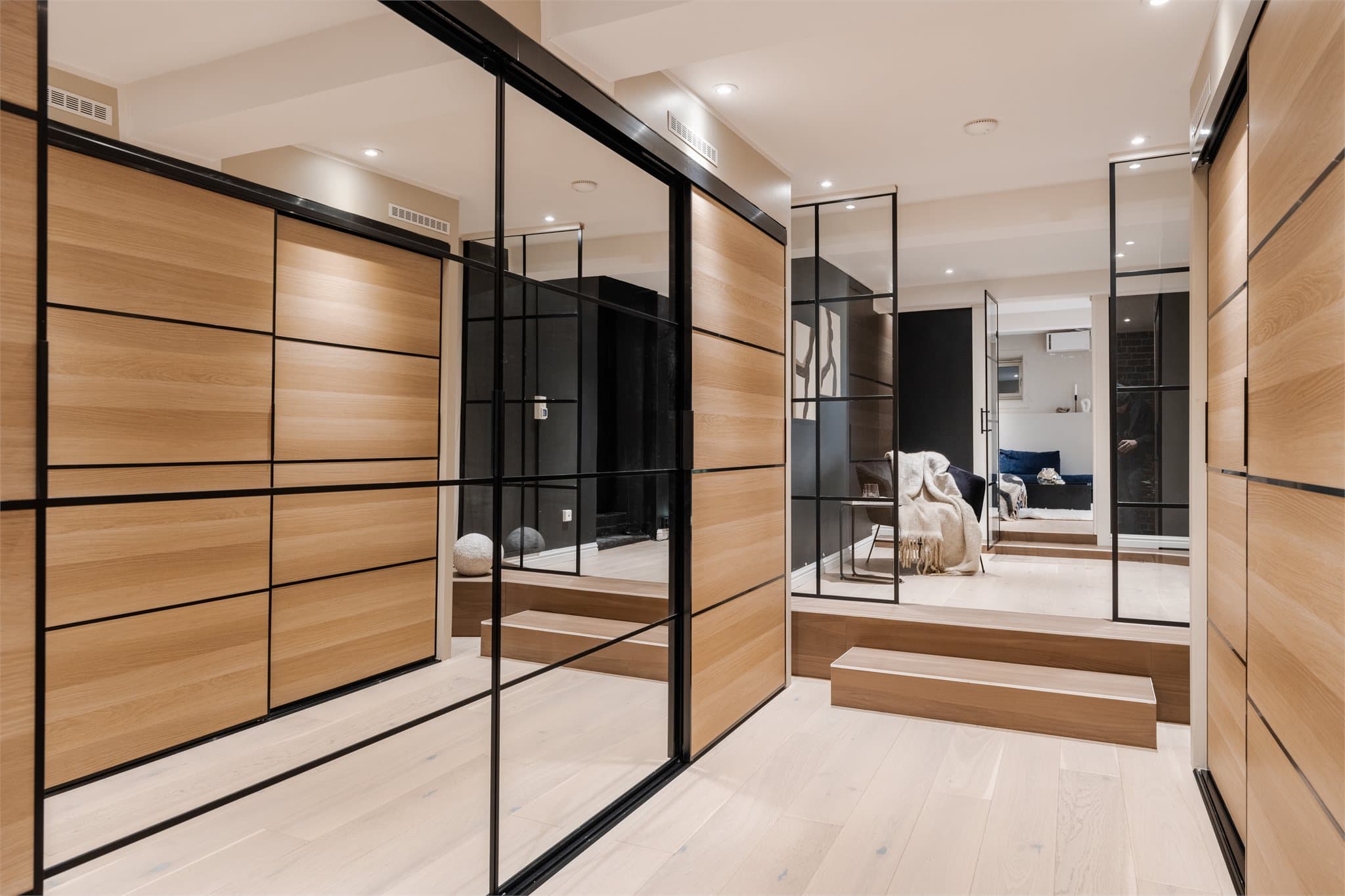 Gangen i underetasjen har spesialtilpassede garderobeskap og industrielle glassvegger.