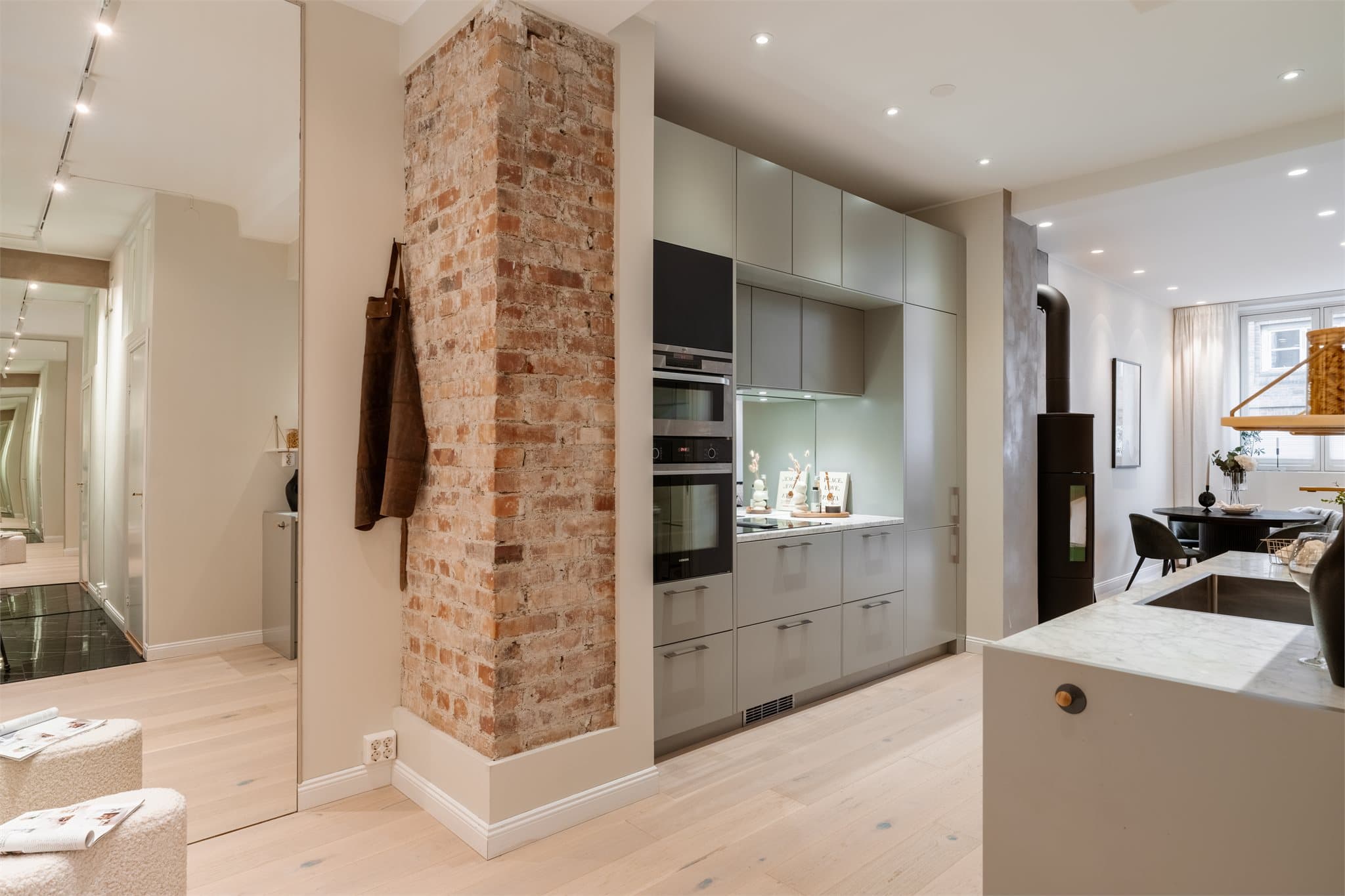 En eksponert teglsteinsvegg gir kjøkkenet en særegen og klassisk karakter.